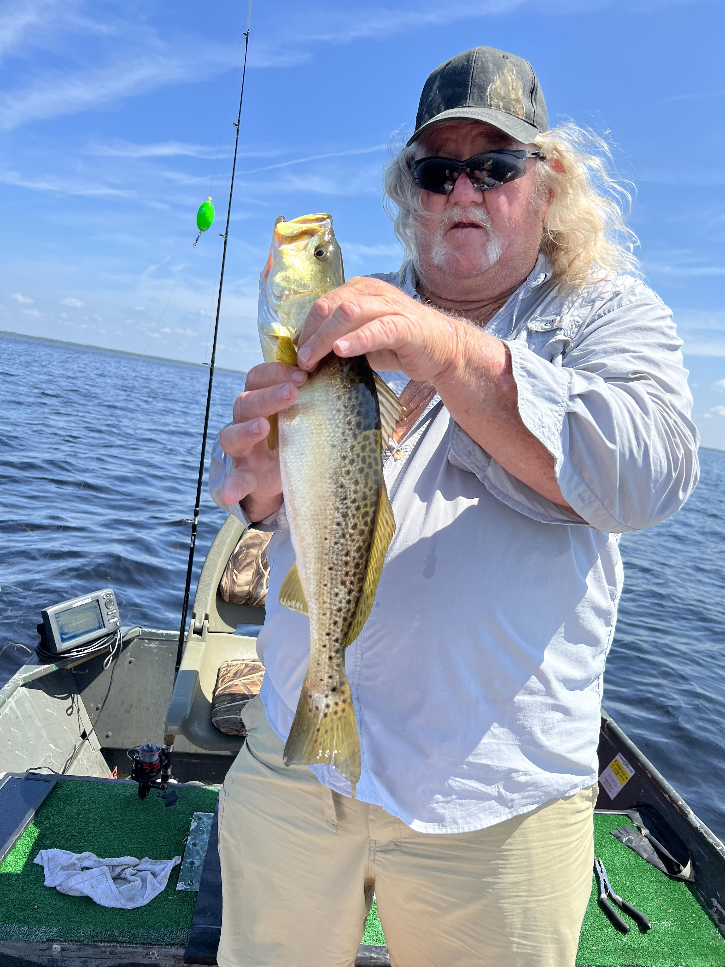A man holding a fish in a boat