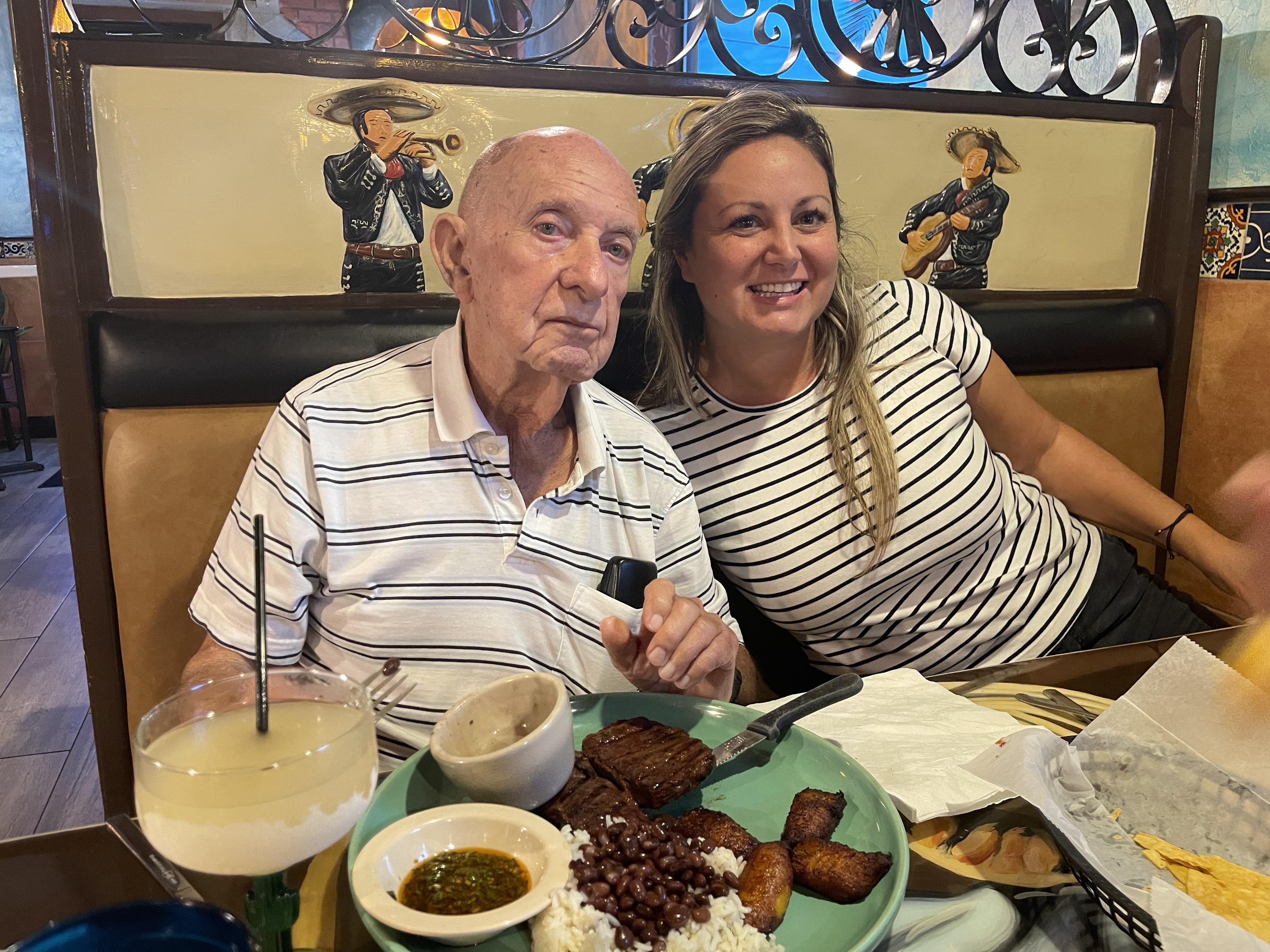 A man and woman sitting at a table with food