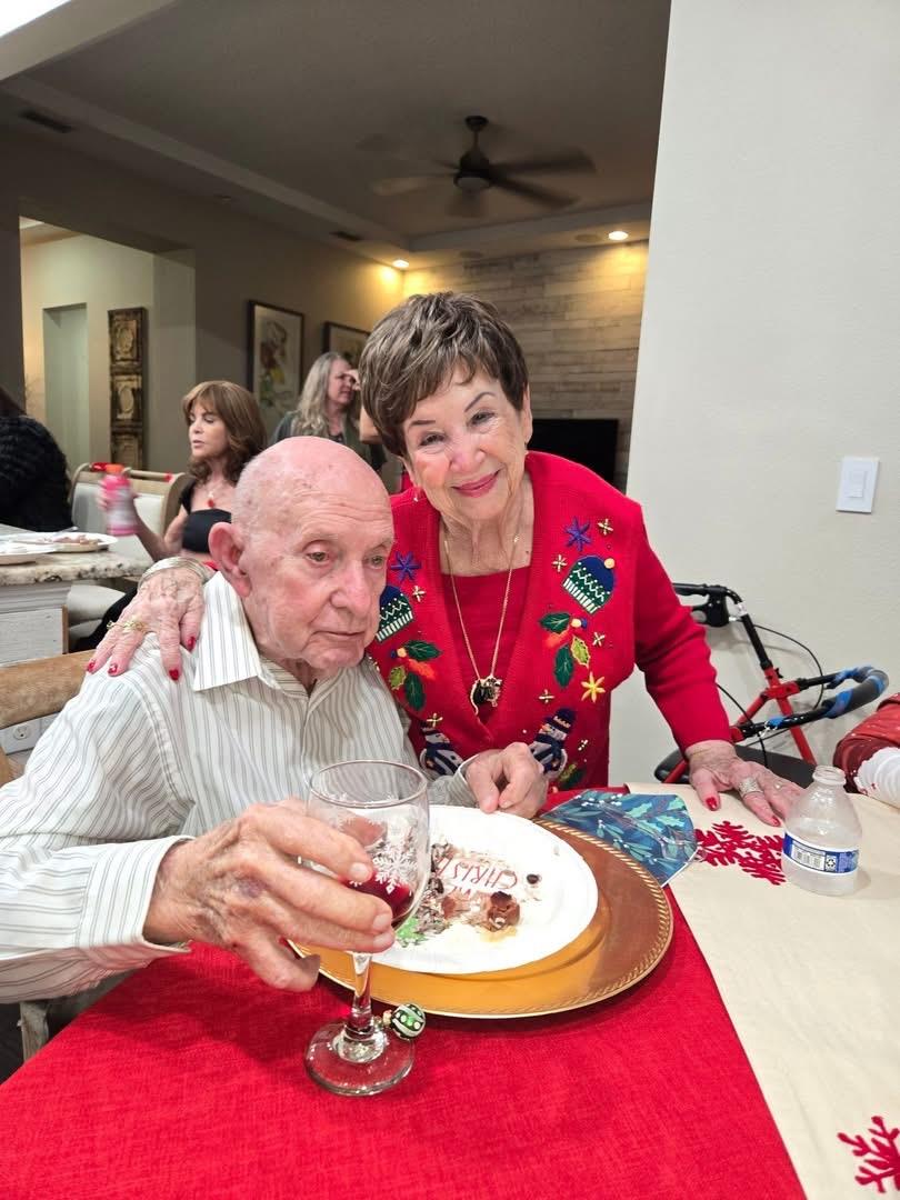 A man and woman sitting at a table with a plate of food