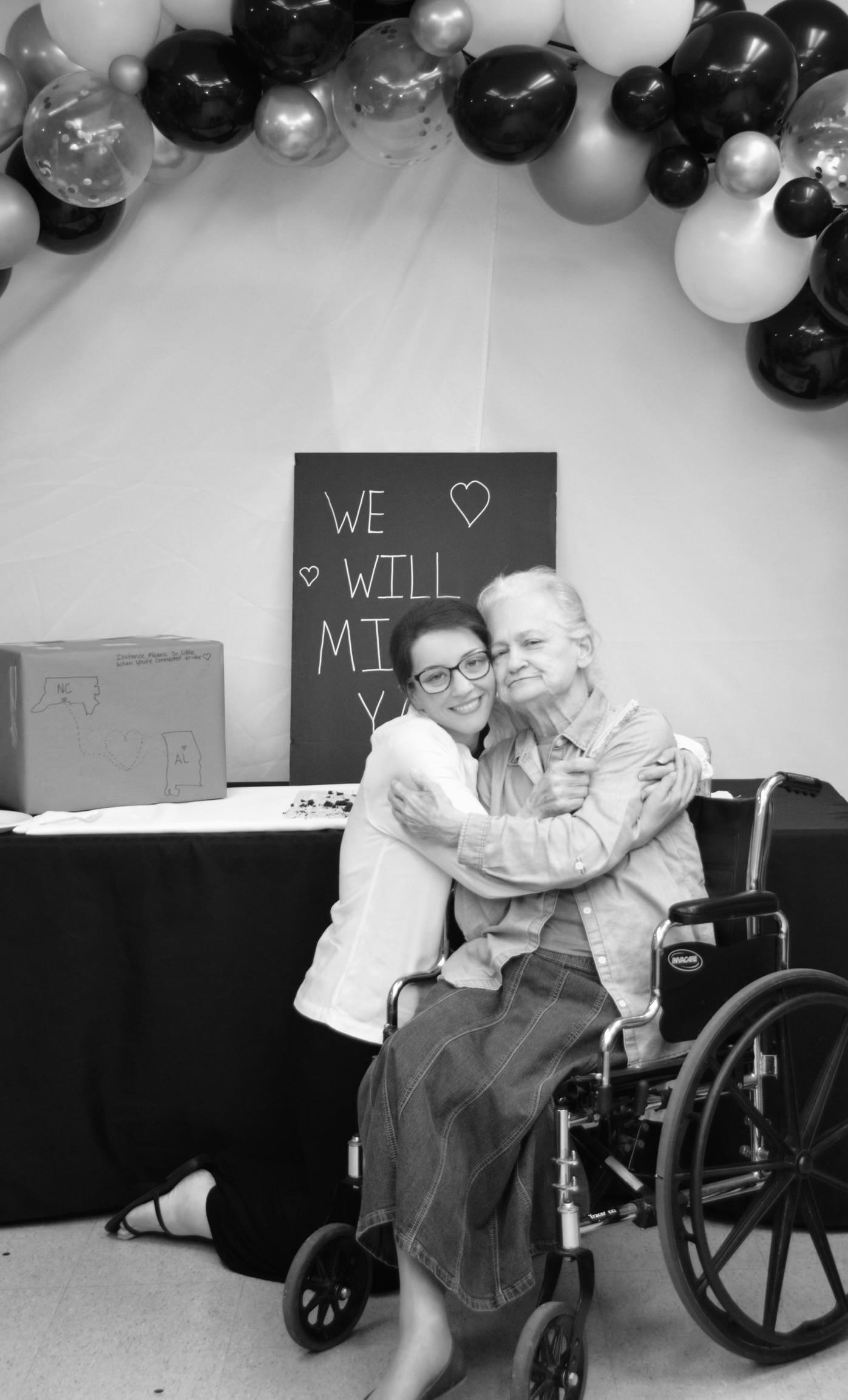 A woman hugging an older woman in a wheelchair