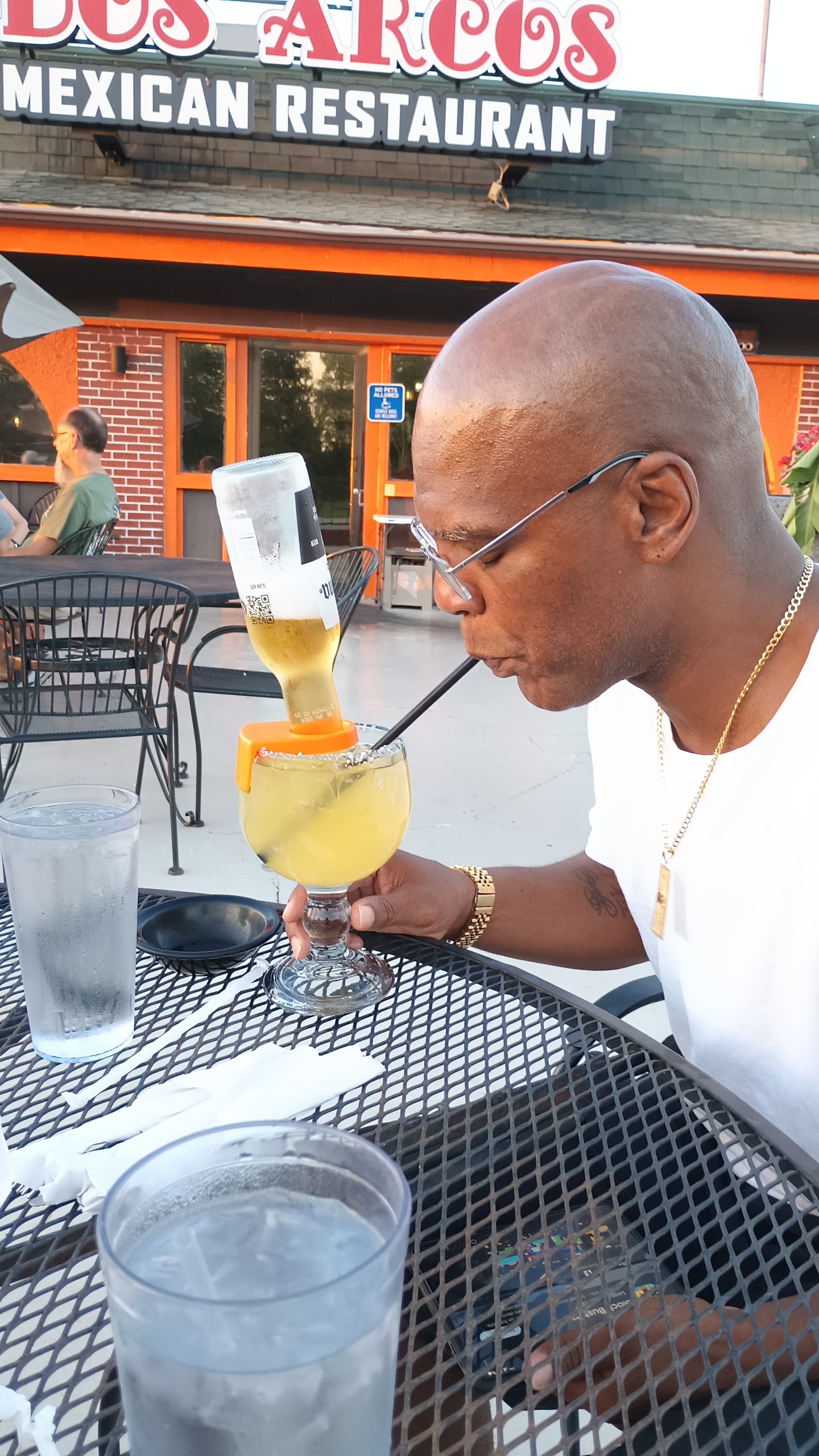 A man drinking from a glass with a straw