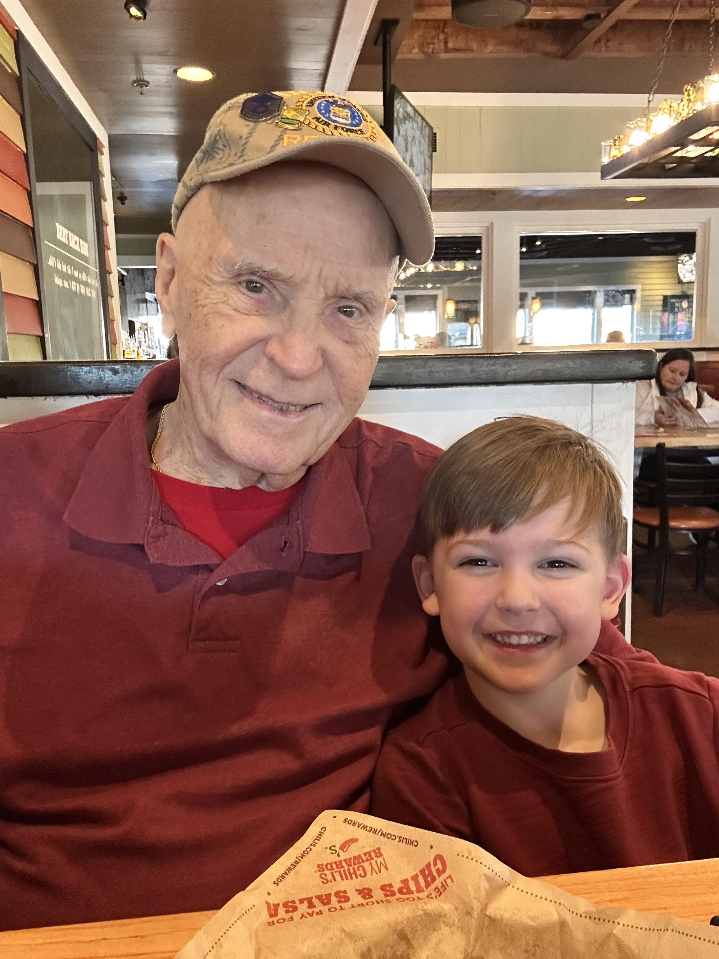 An old man and boy posing for a picture