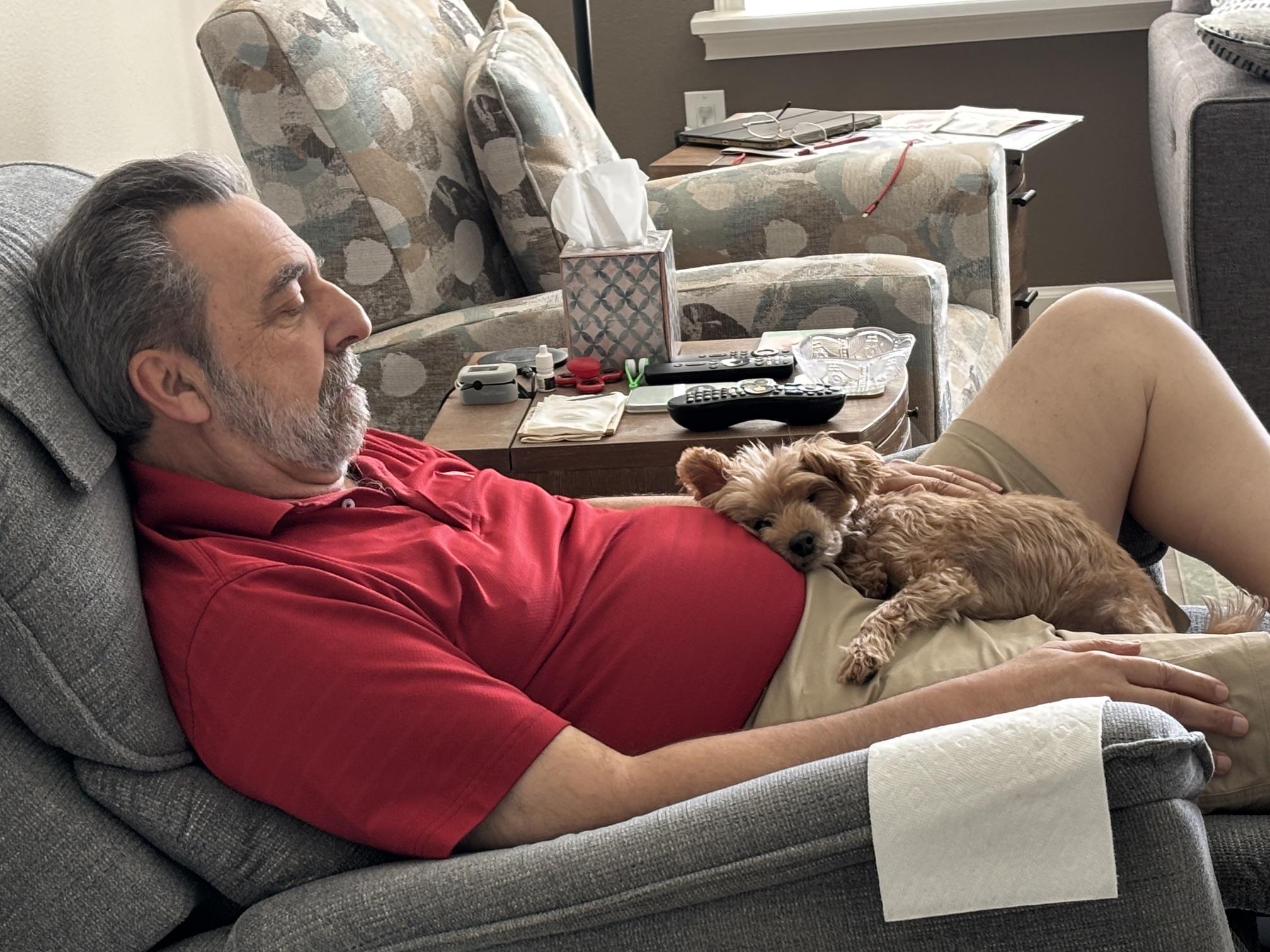 A man lying on a couch with a dog