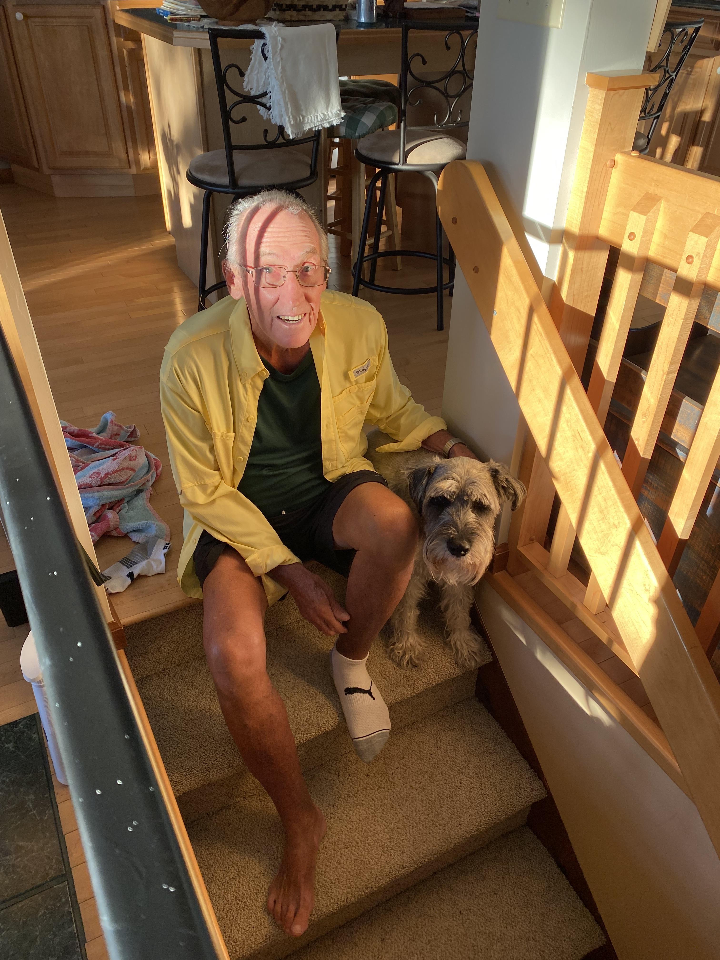 A man sitting on stairs with a dog