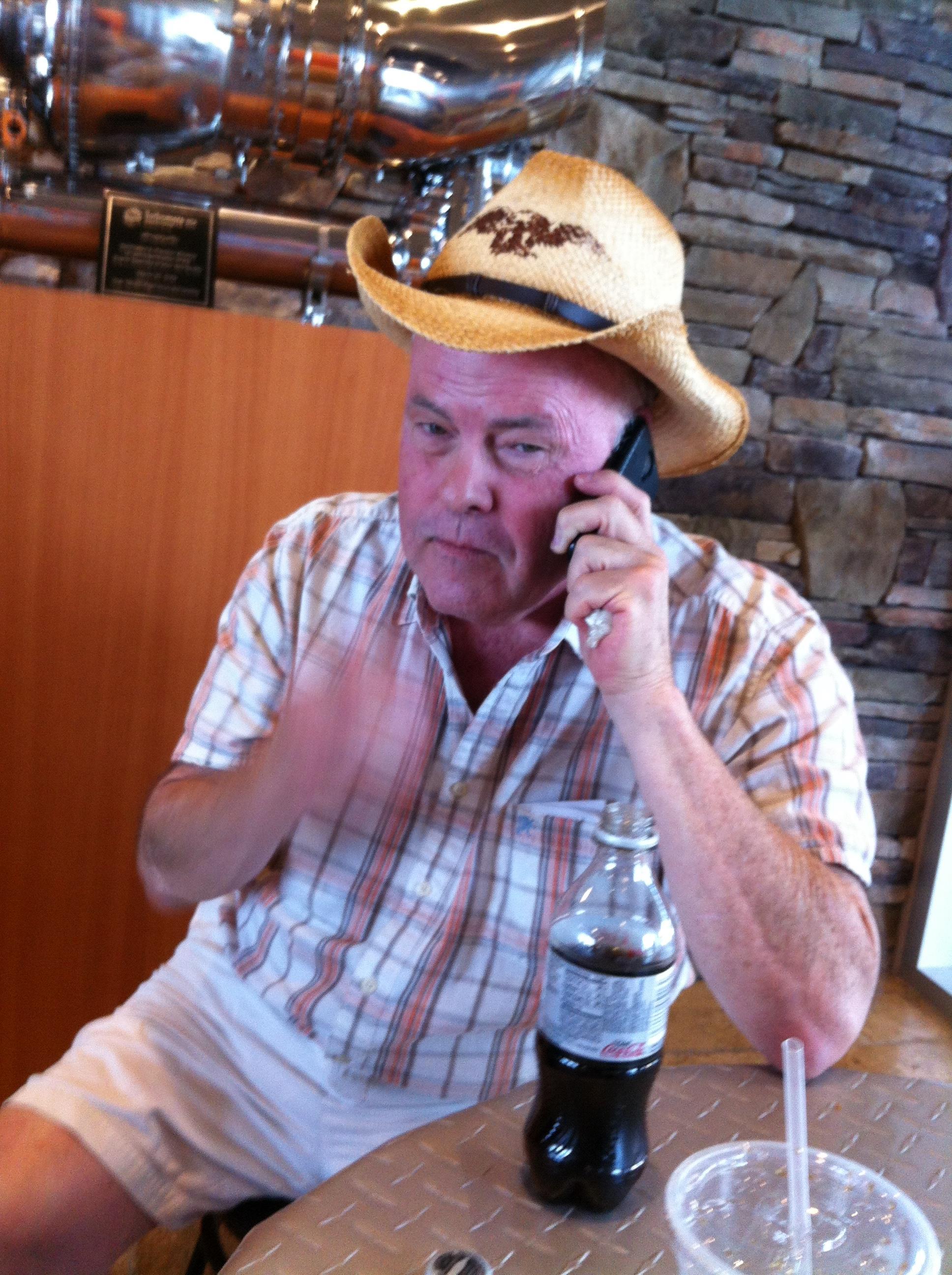 A man in a cowboy hat talking on a cell phone