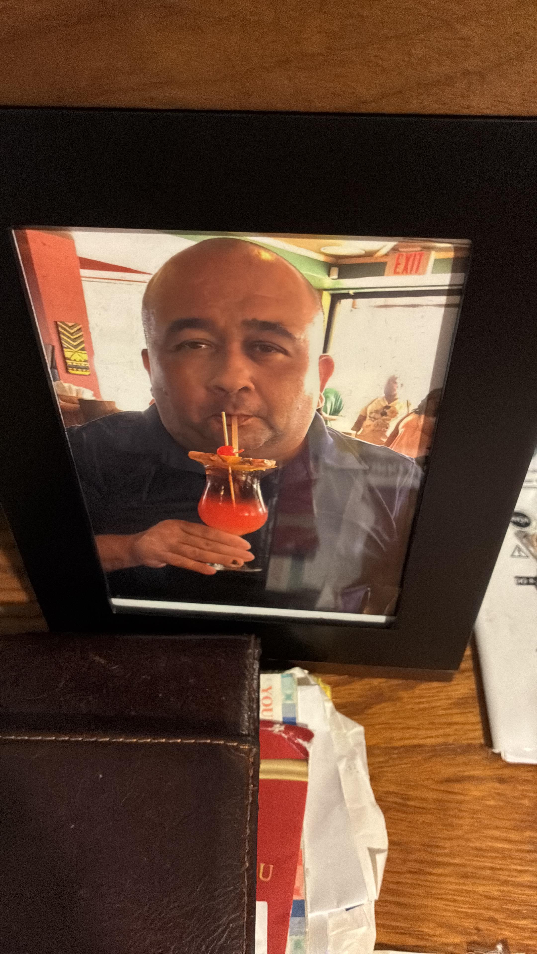 A framed picture of a man drinking from a drink