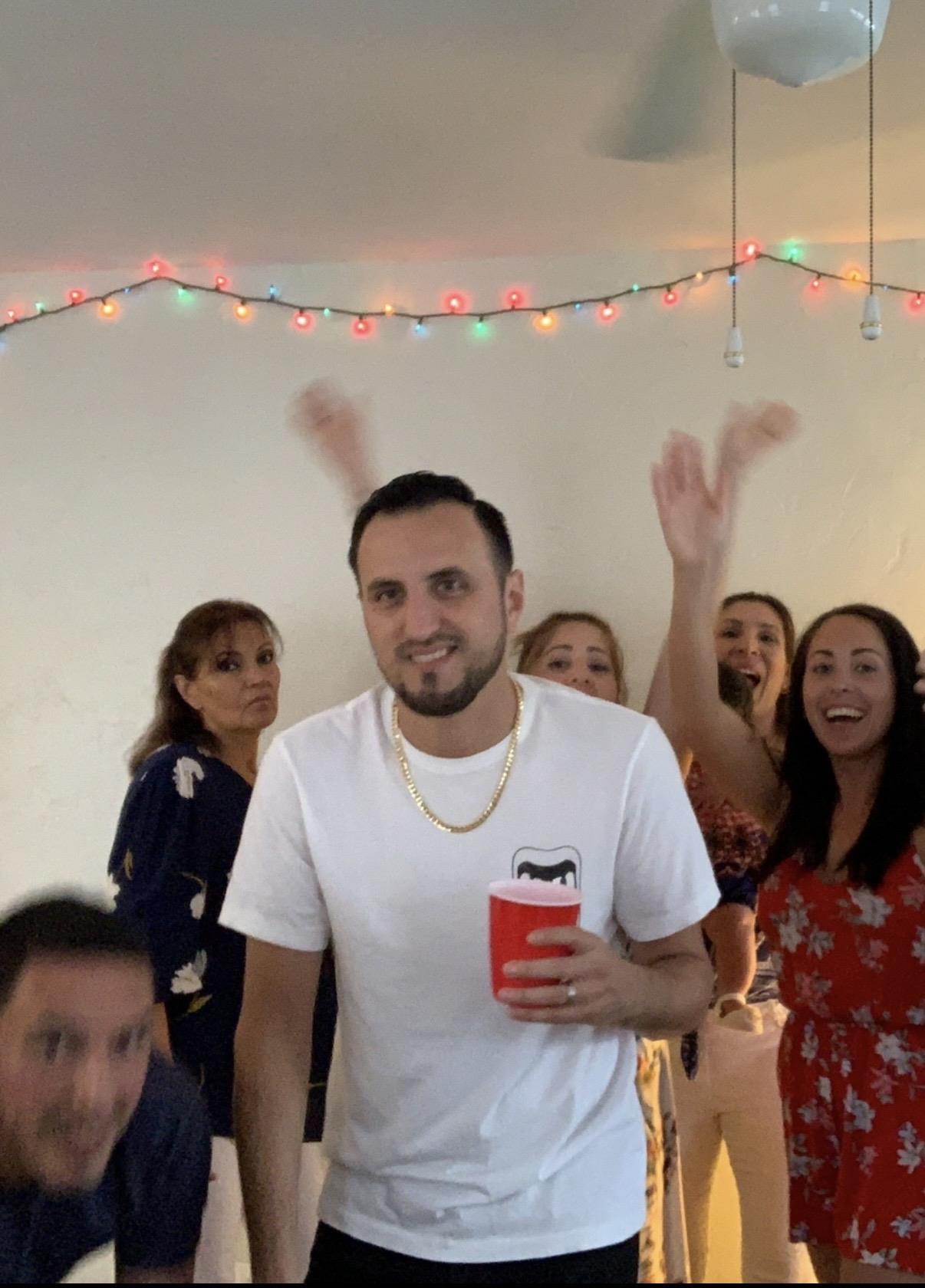 A man holding a red cup and raising his hands