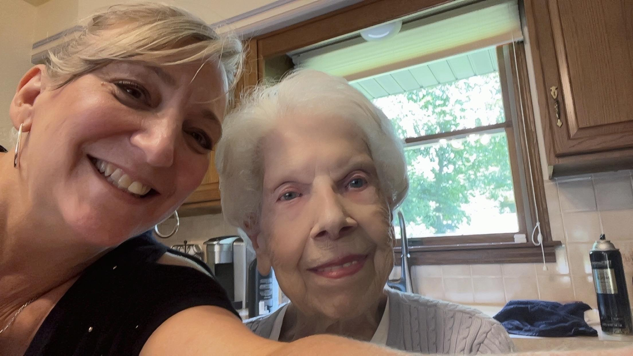 A woman taking a selfie with an older woman
