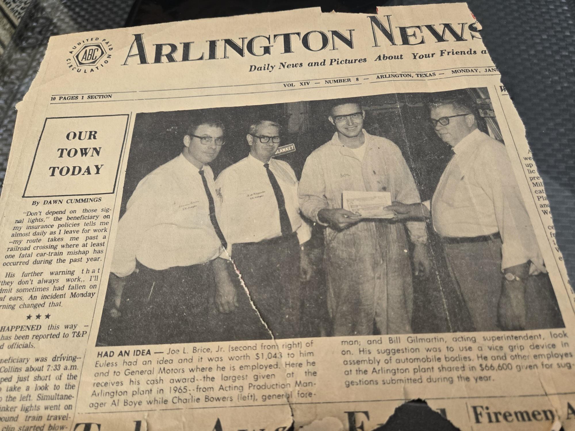 A group of men standing in front of a newspaper