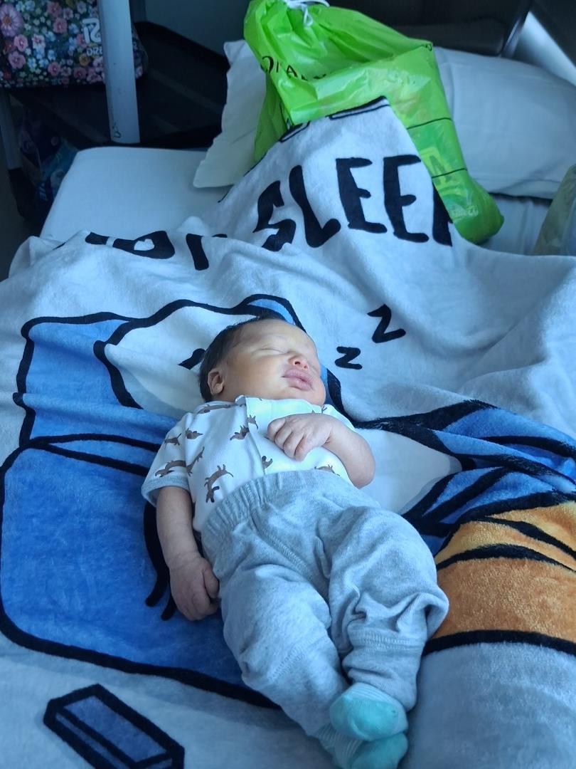 A baby sleeping in a bed