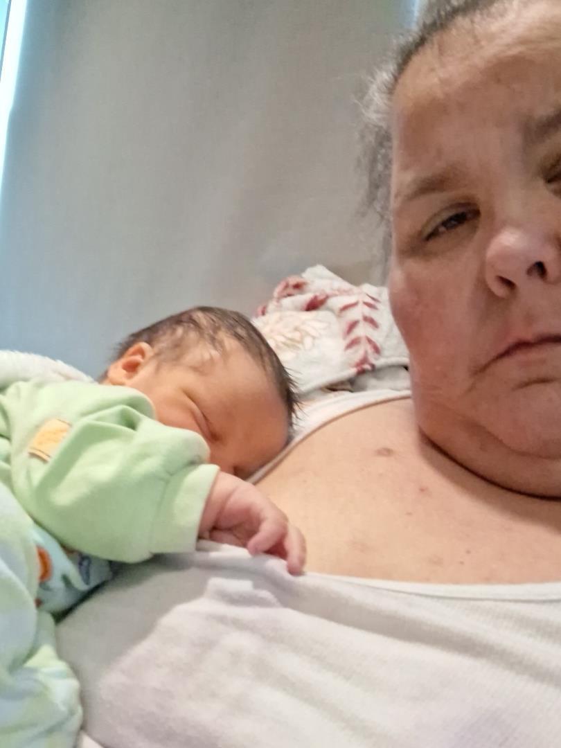 A woman lying on a bed with a baby
