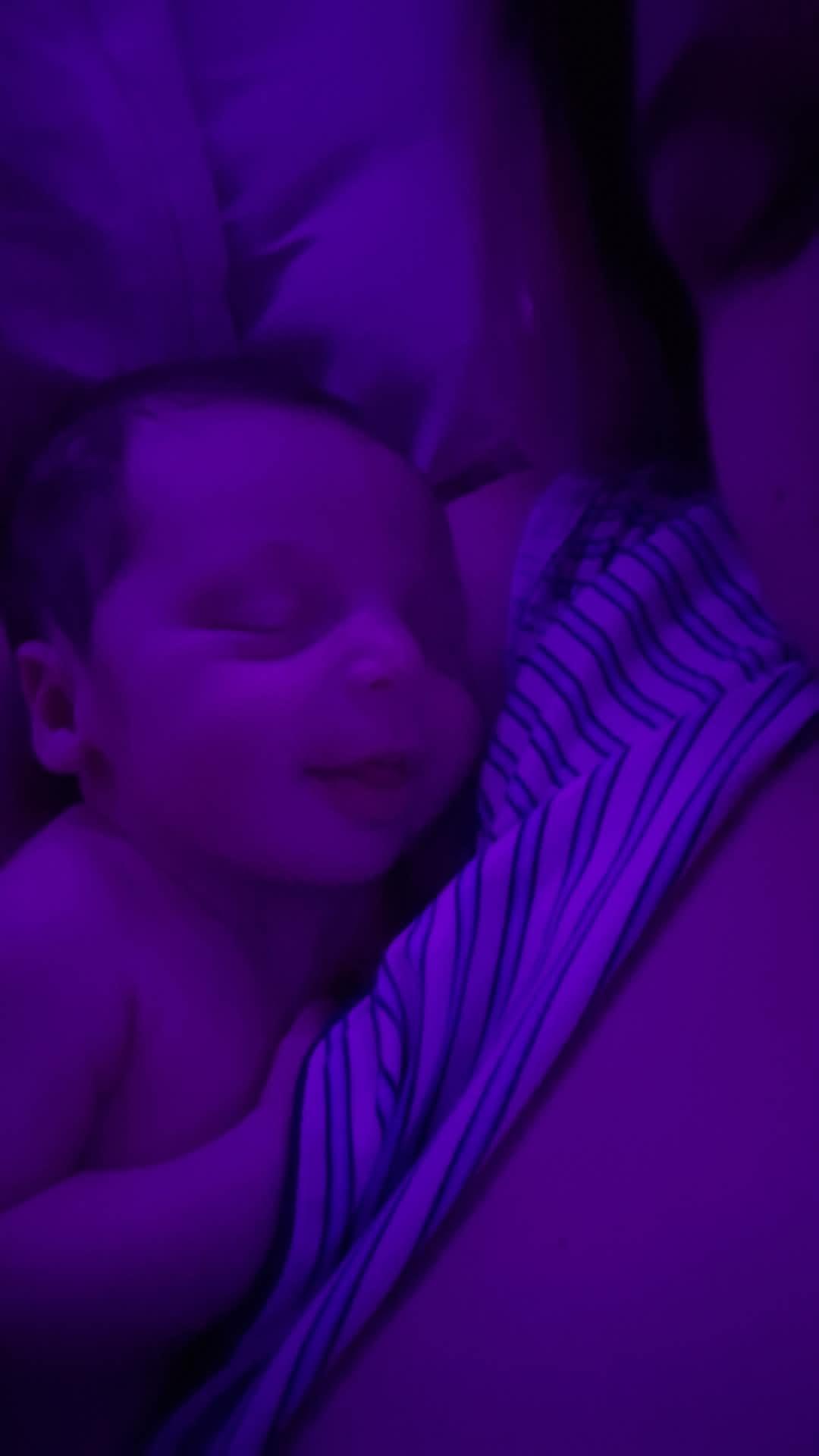 A baby sleeping in a woman's arms