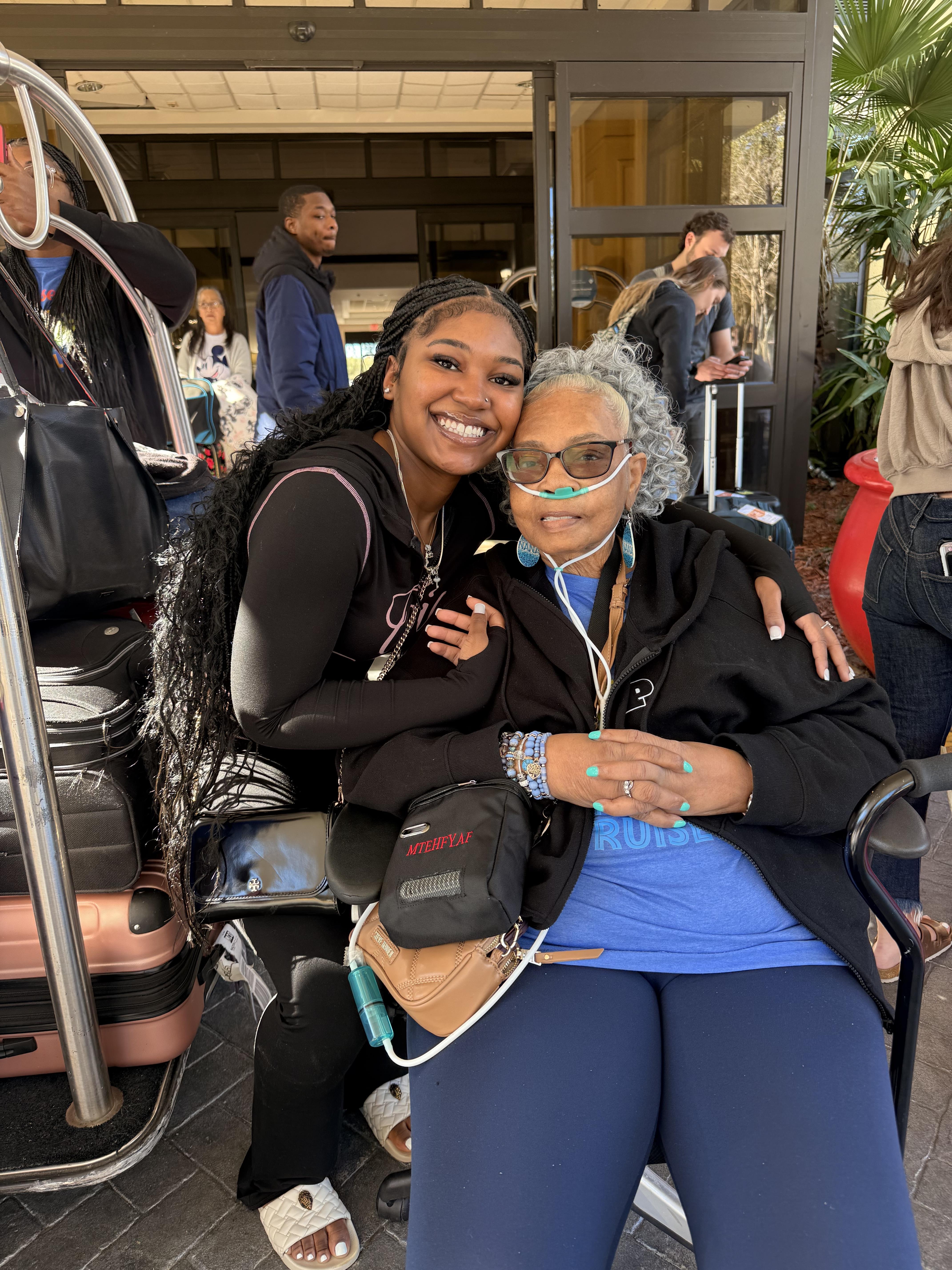 A woman sitting on a wheelchair with a woman in a wheelchair