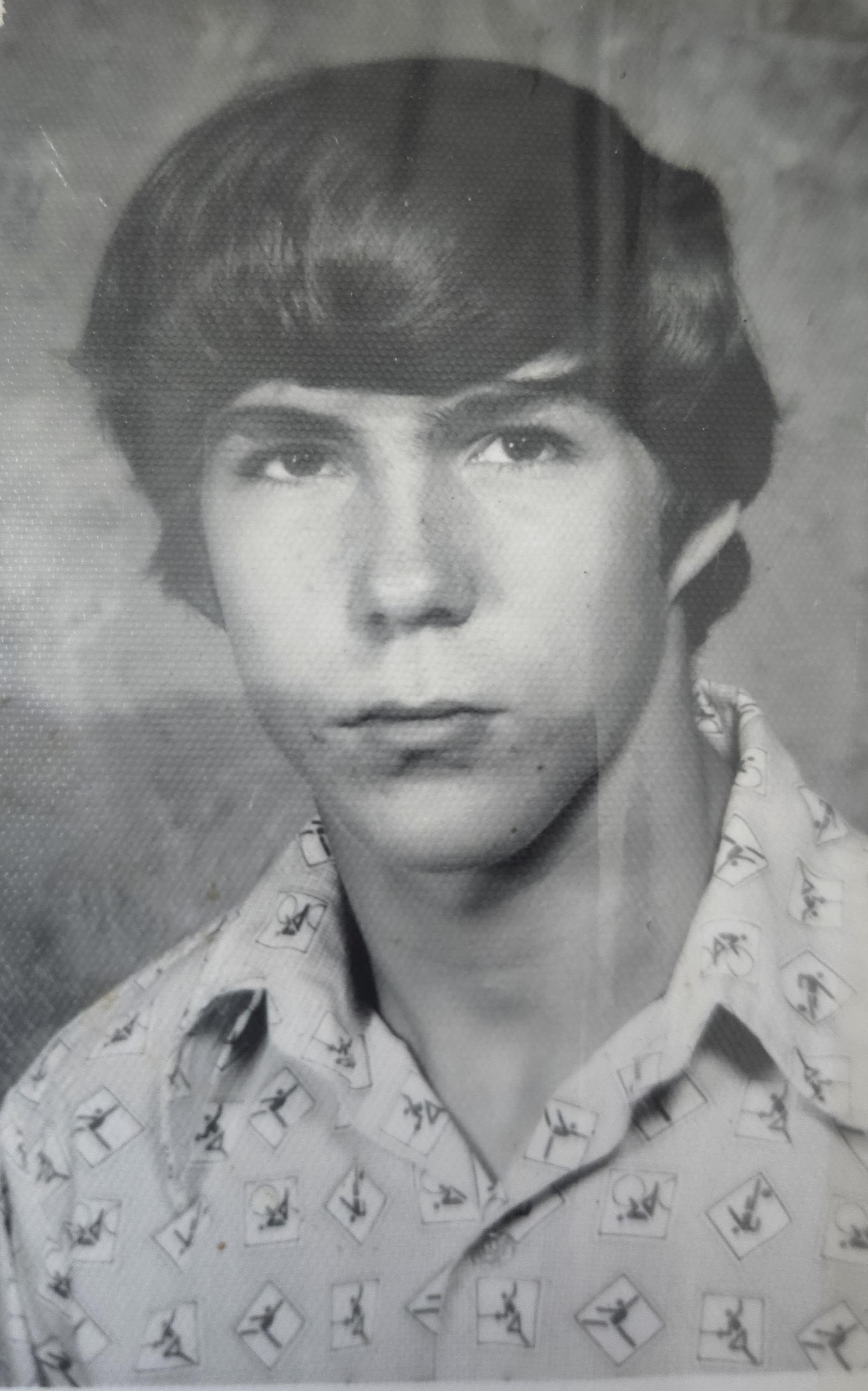 A man with short hair wearing a white shirt