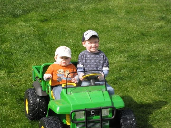 Two children riding a toy tractor