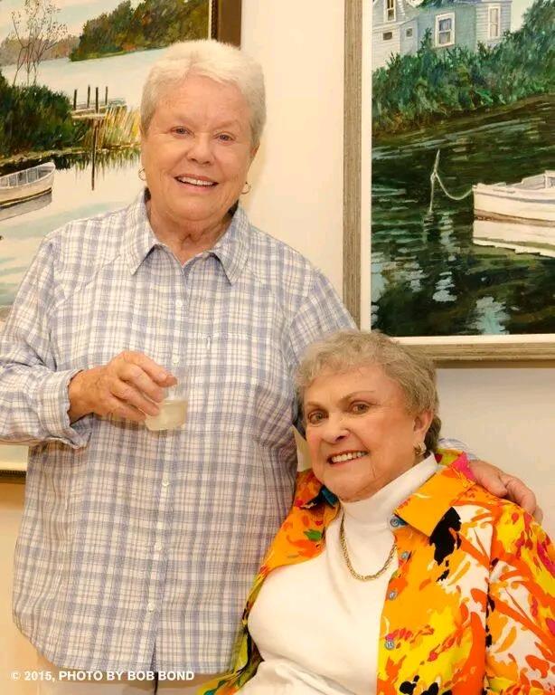 A woman standing next to another woman