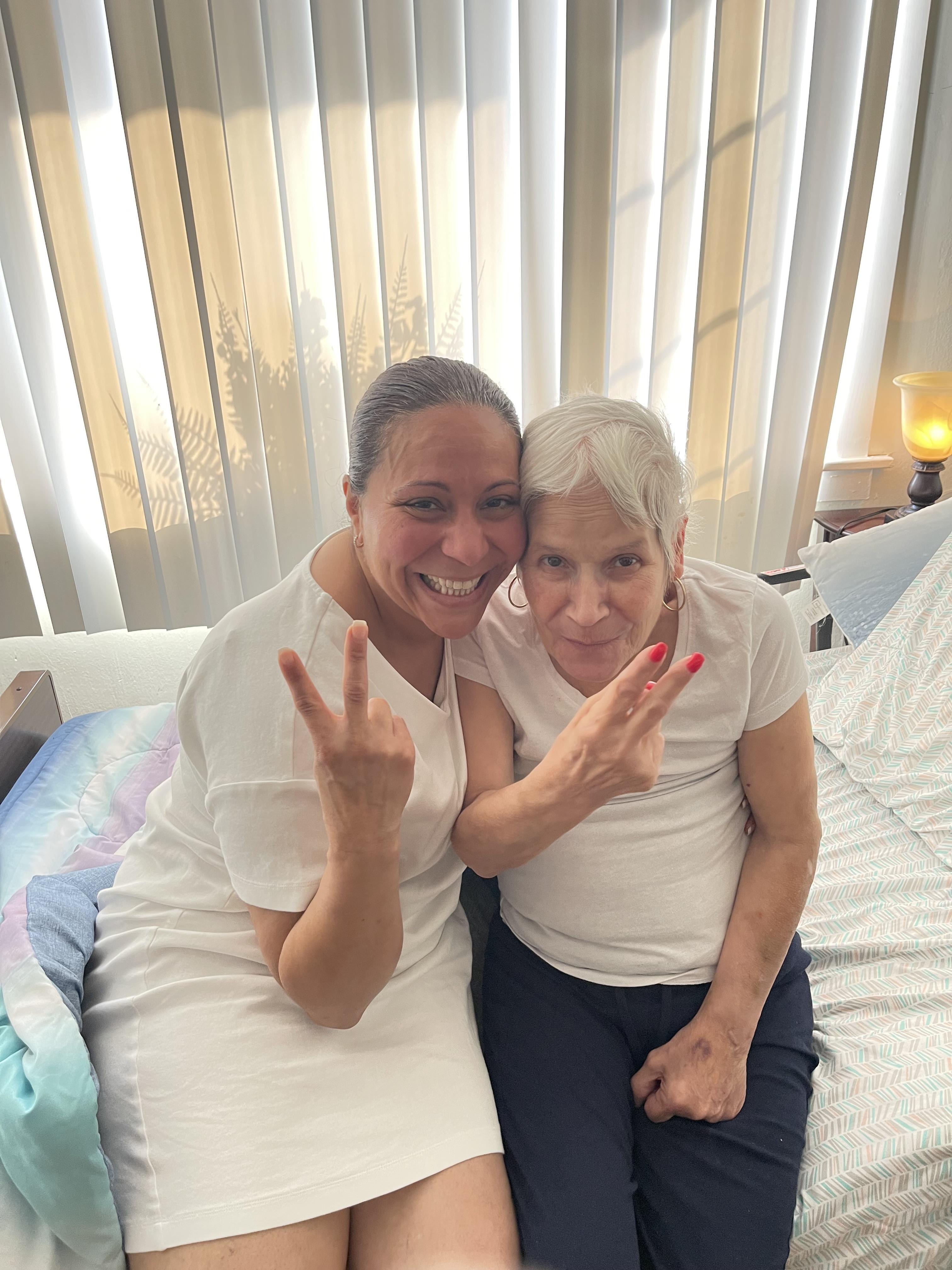 Two women sitting on a bed