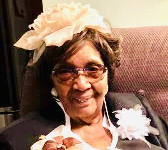 A woman wearing glasses and a flower in her hair