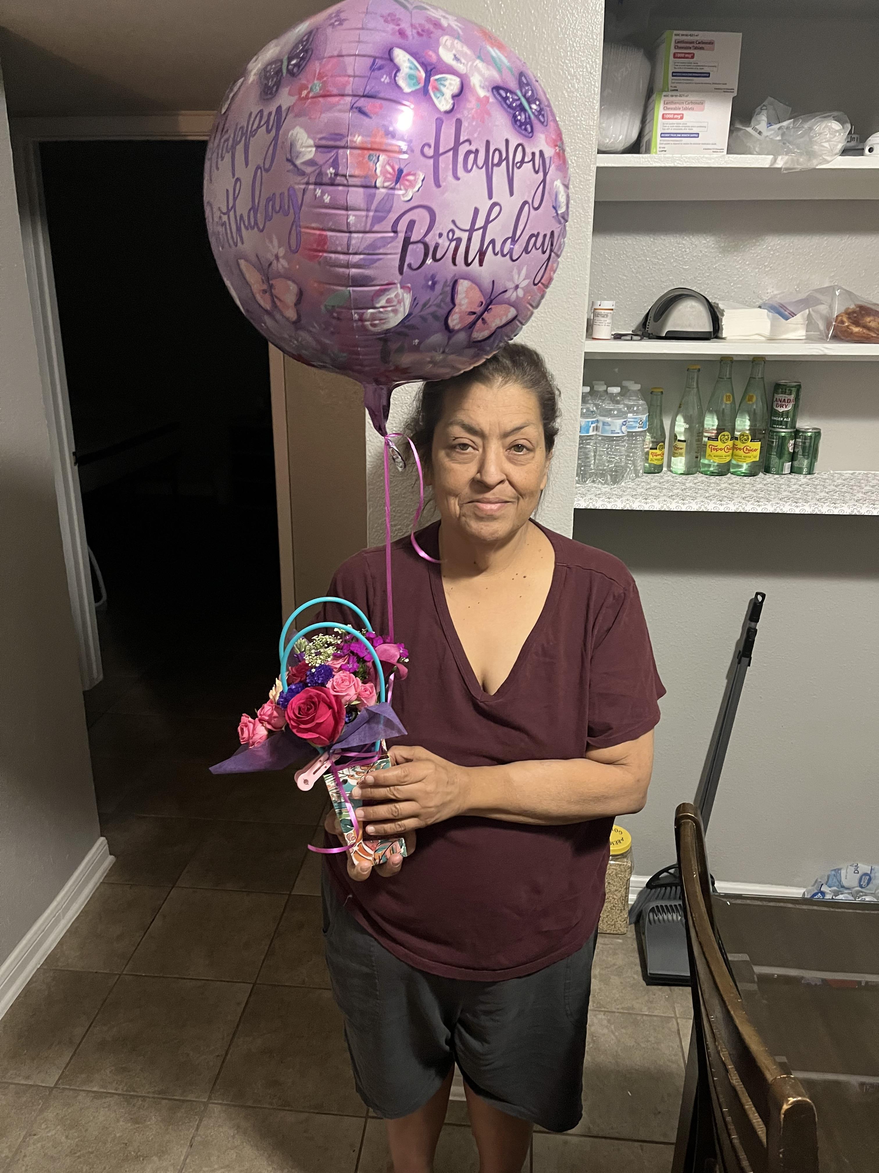 A woman holding a balloon and a flower