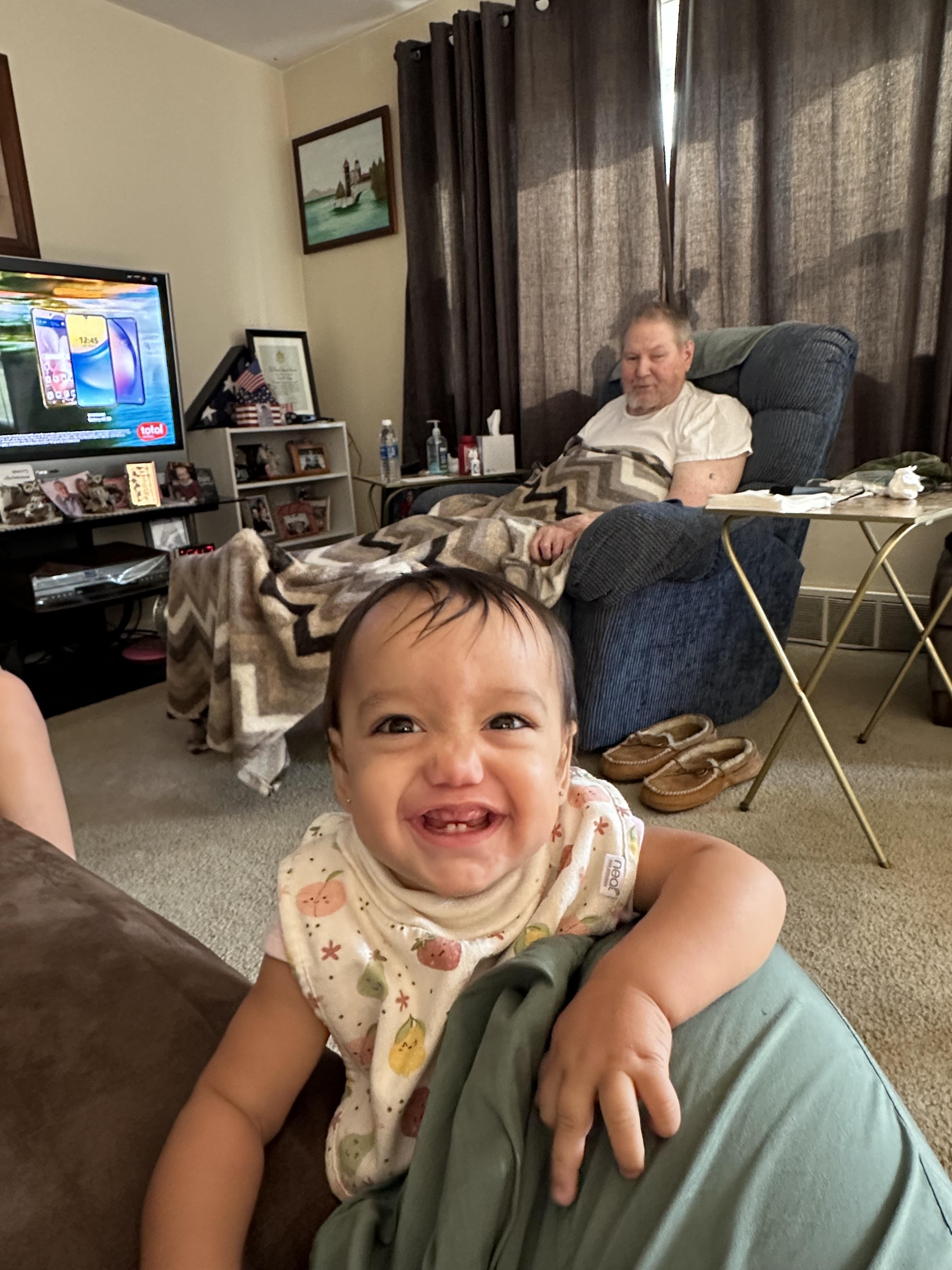 A baby sitting on a couch in a living room