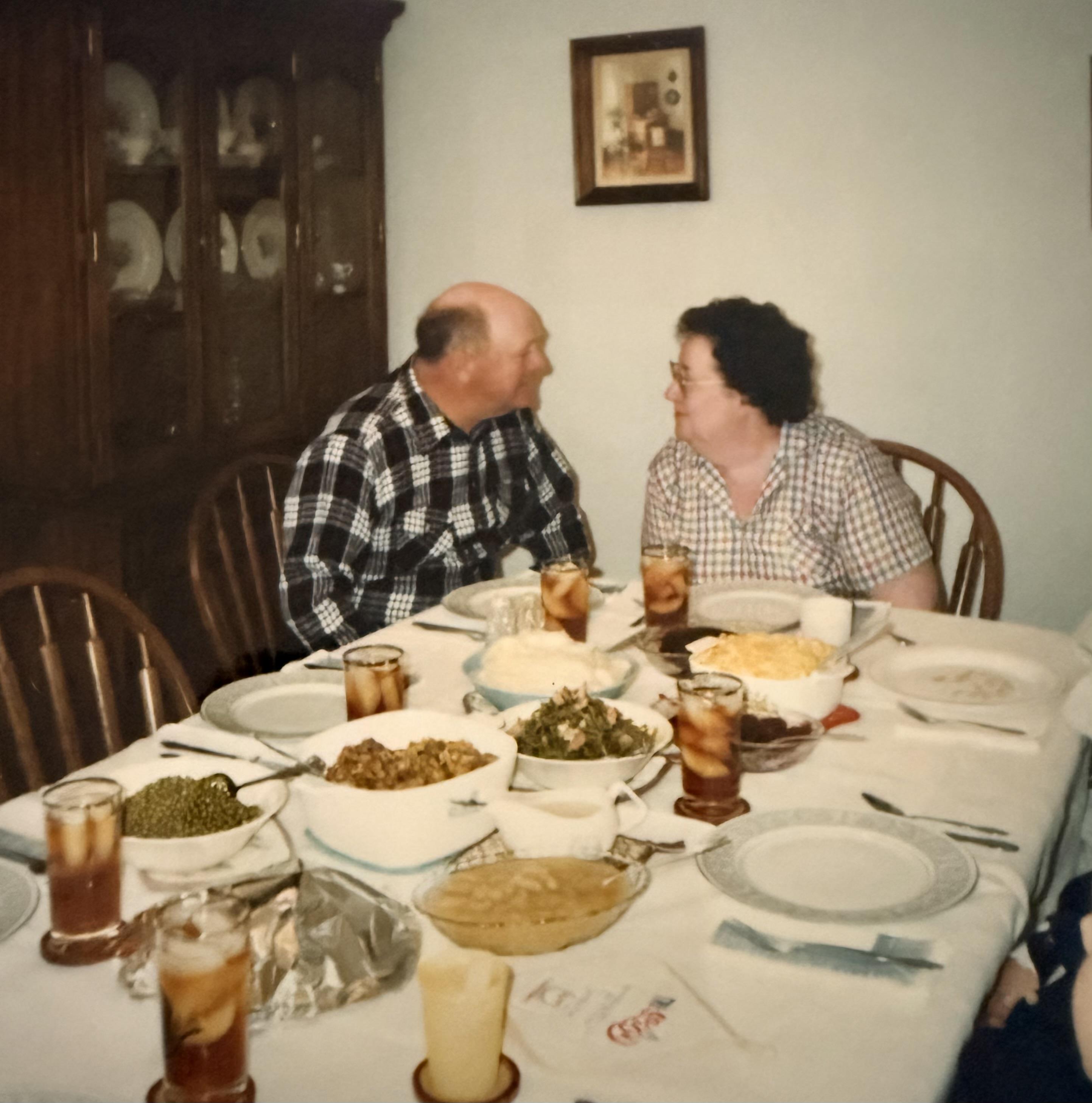 A man and woman sitting at a table with food