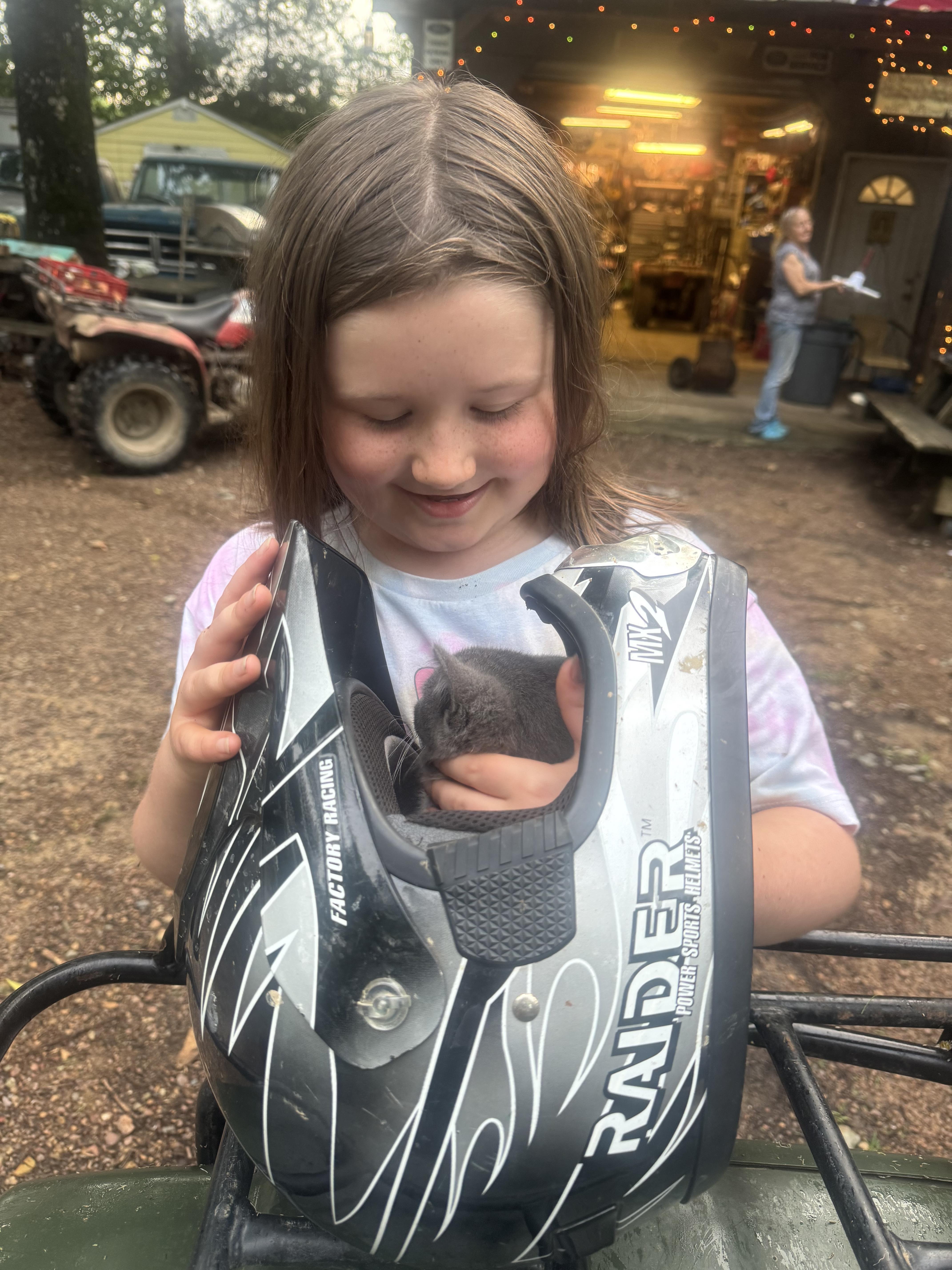 A girl holding a cat in a motorcycle