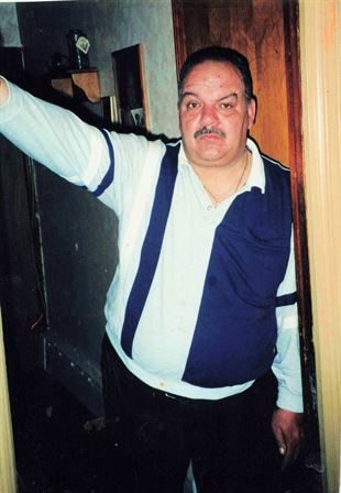 A man with a mustache and a mustache holding his hand up