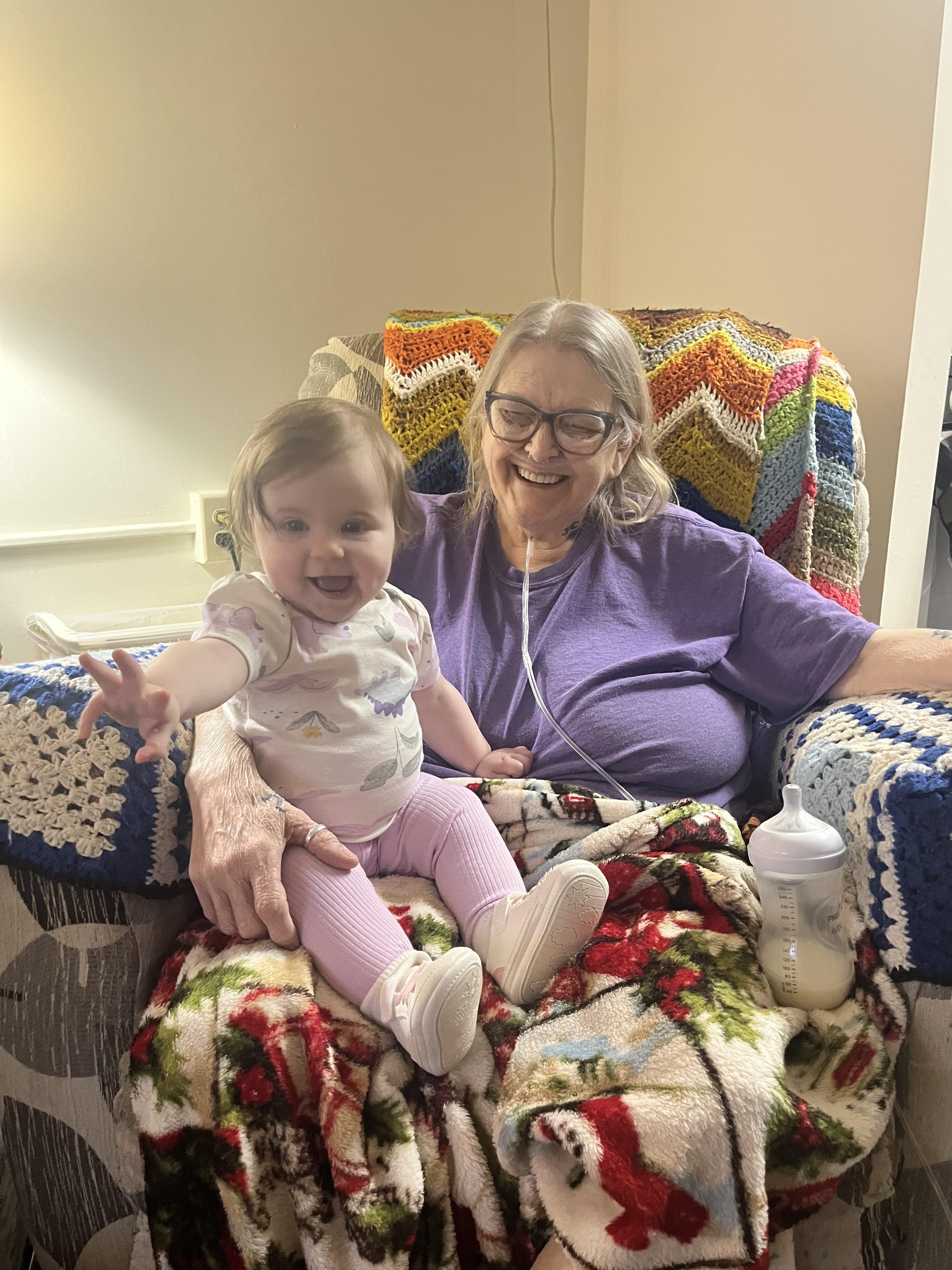 A woman and baby sitting on a chair