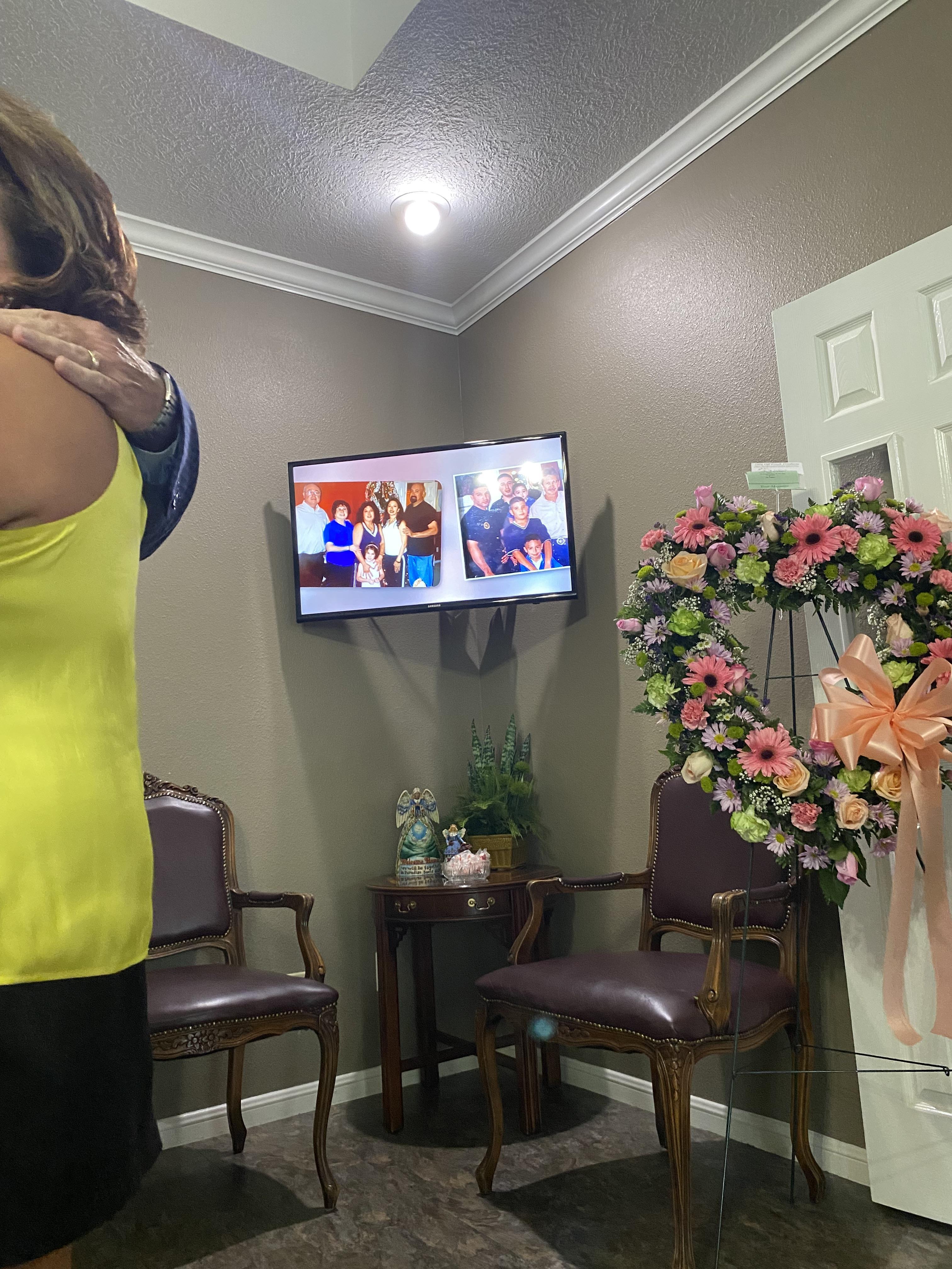 A woman standing in a room with a television and flowers