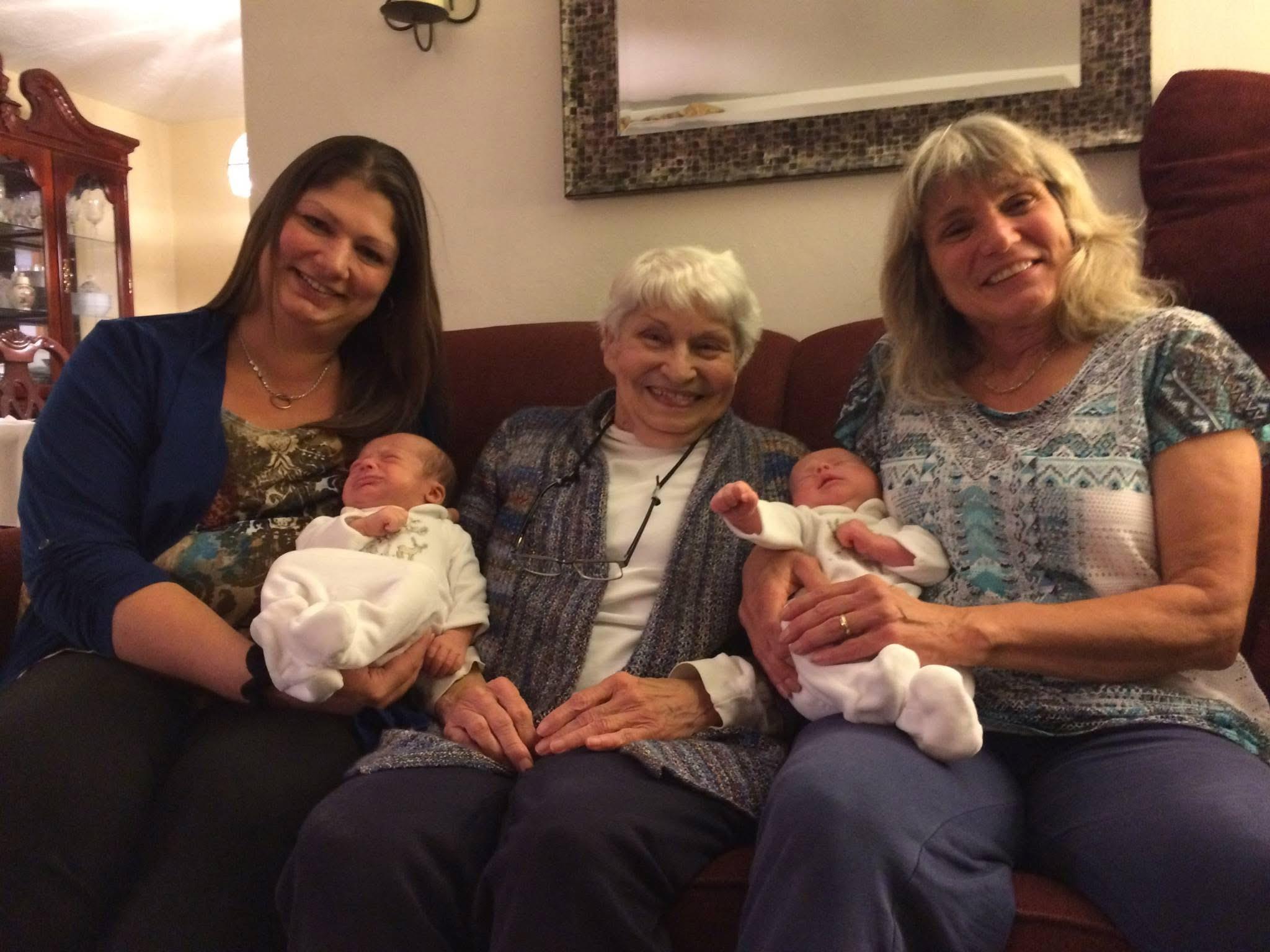A group of women sitting on a couch with a baby