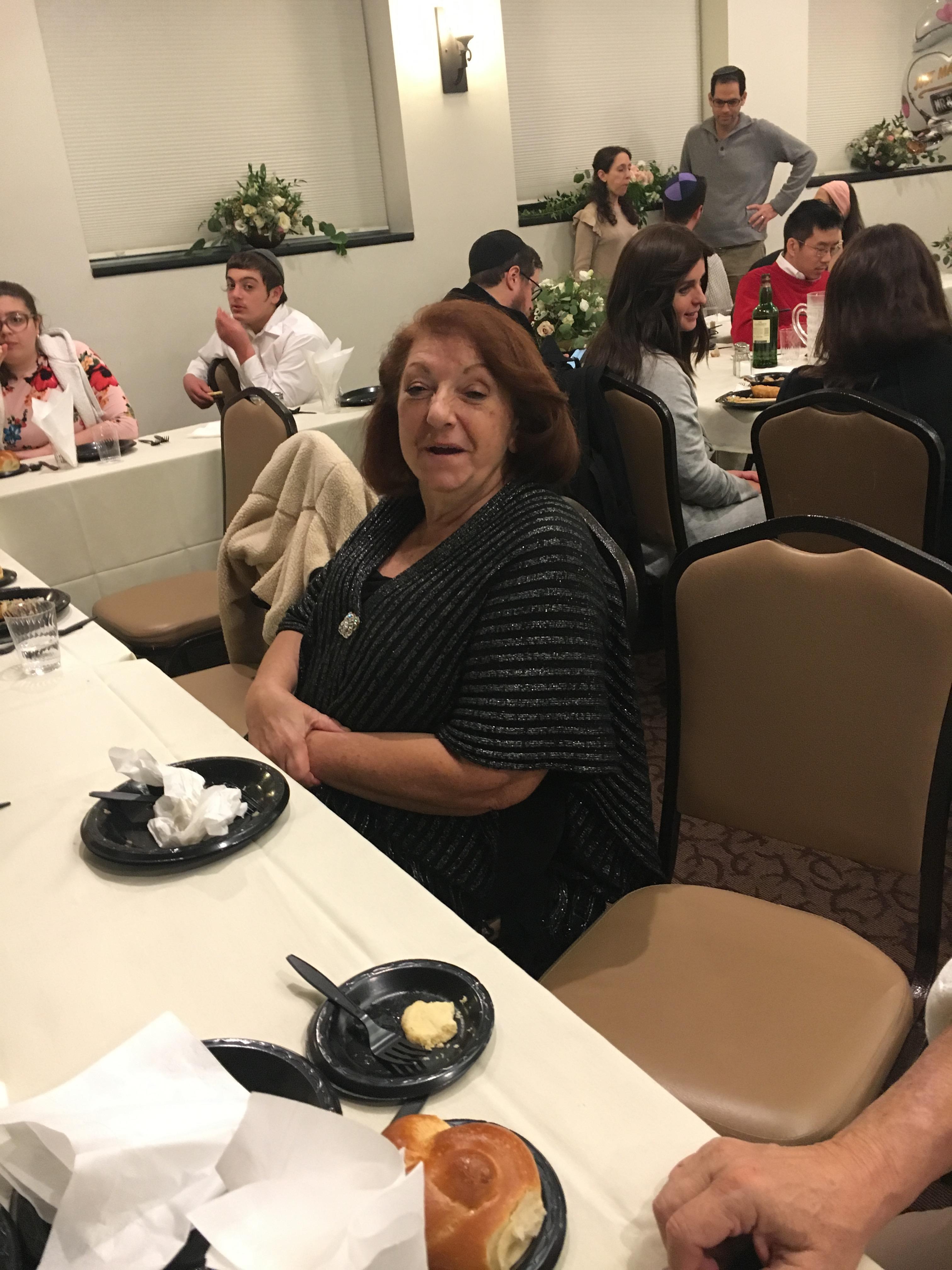 A woman sitting at a table with people around it