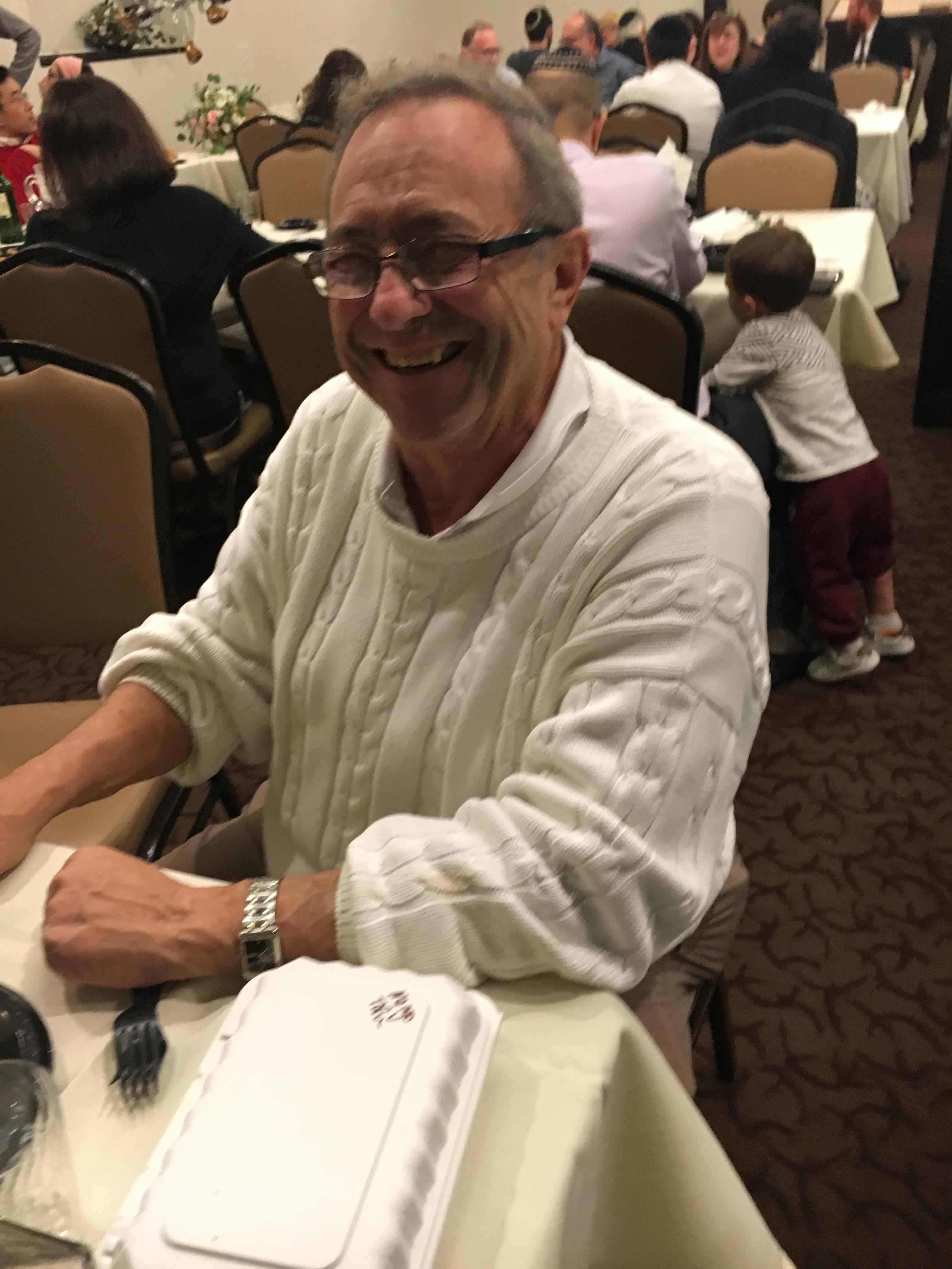 A man sitting at a table smiling