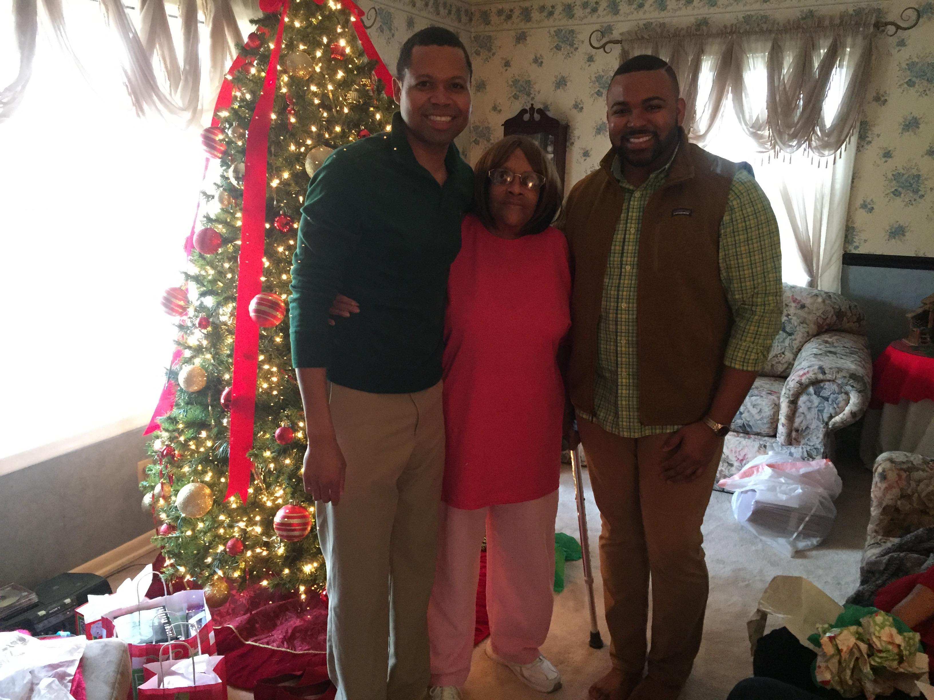 A group of people standing in front of a christmas tree