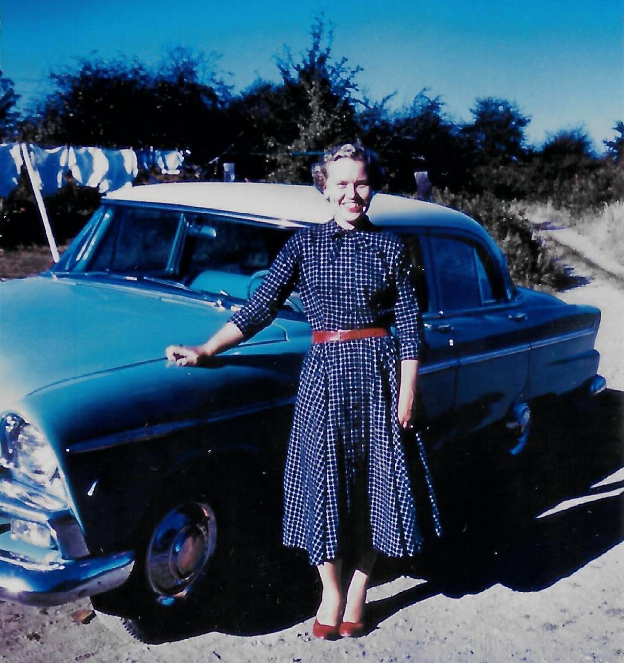 A woman standing next to a car
