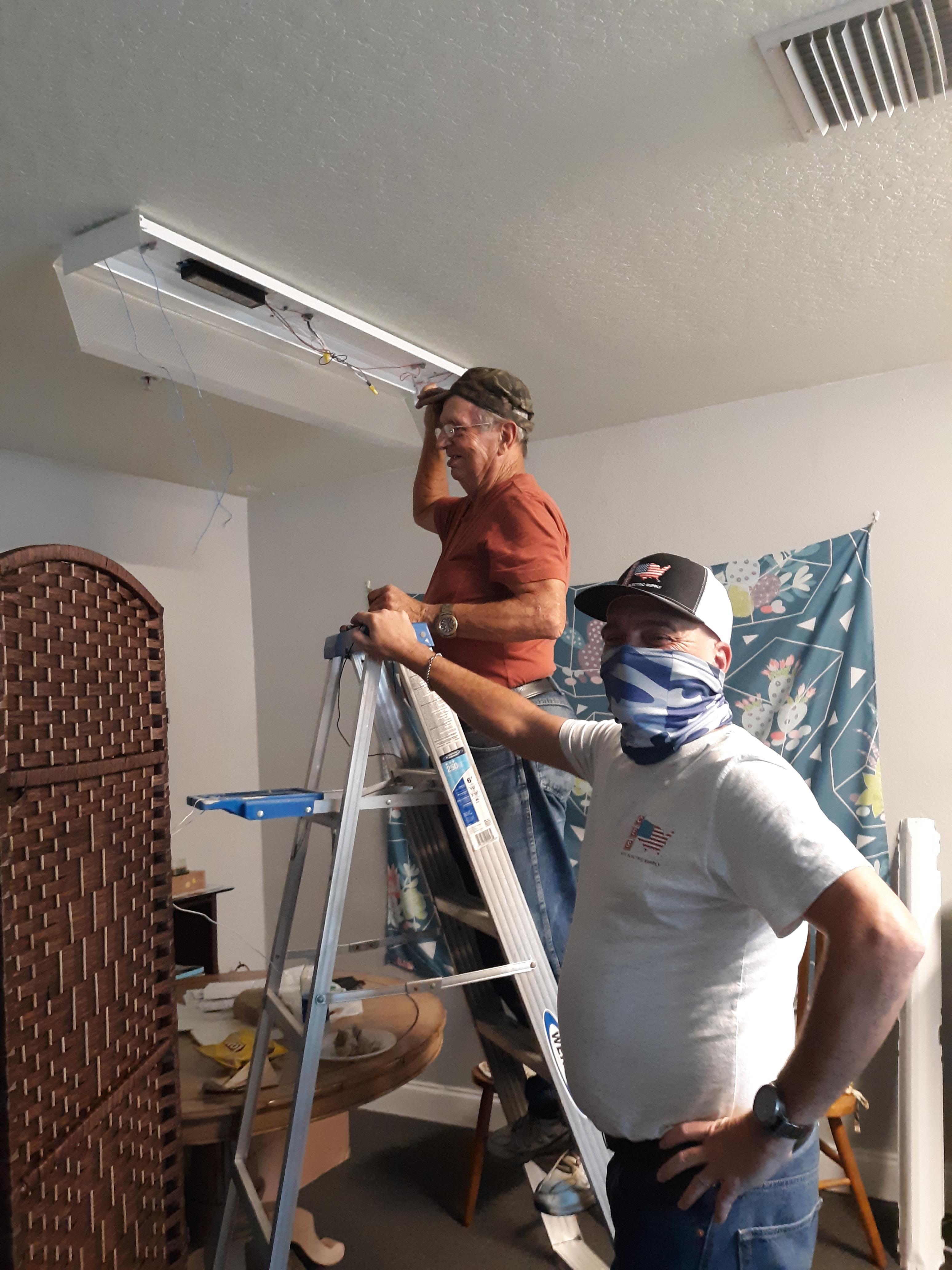 Two men standing on a ladder