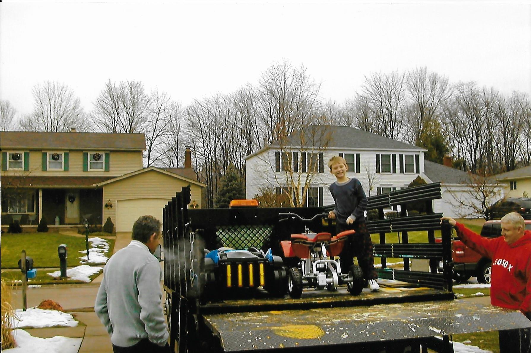 A boy standing next to a small vehicle