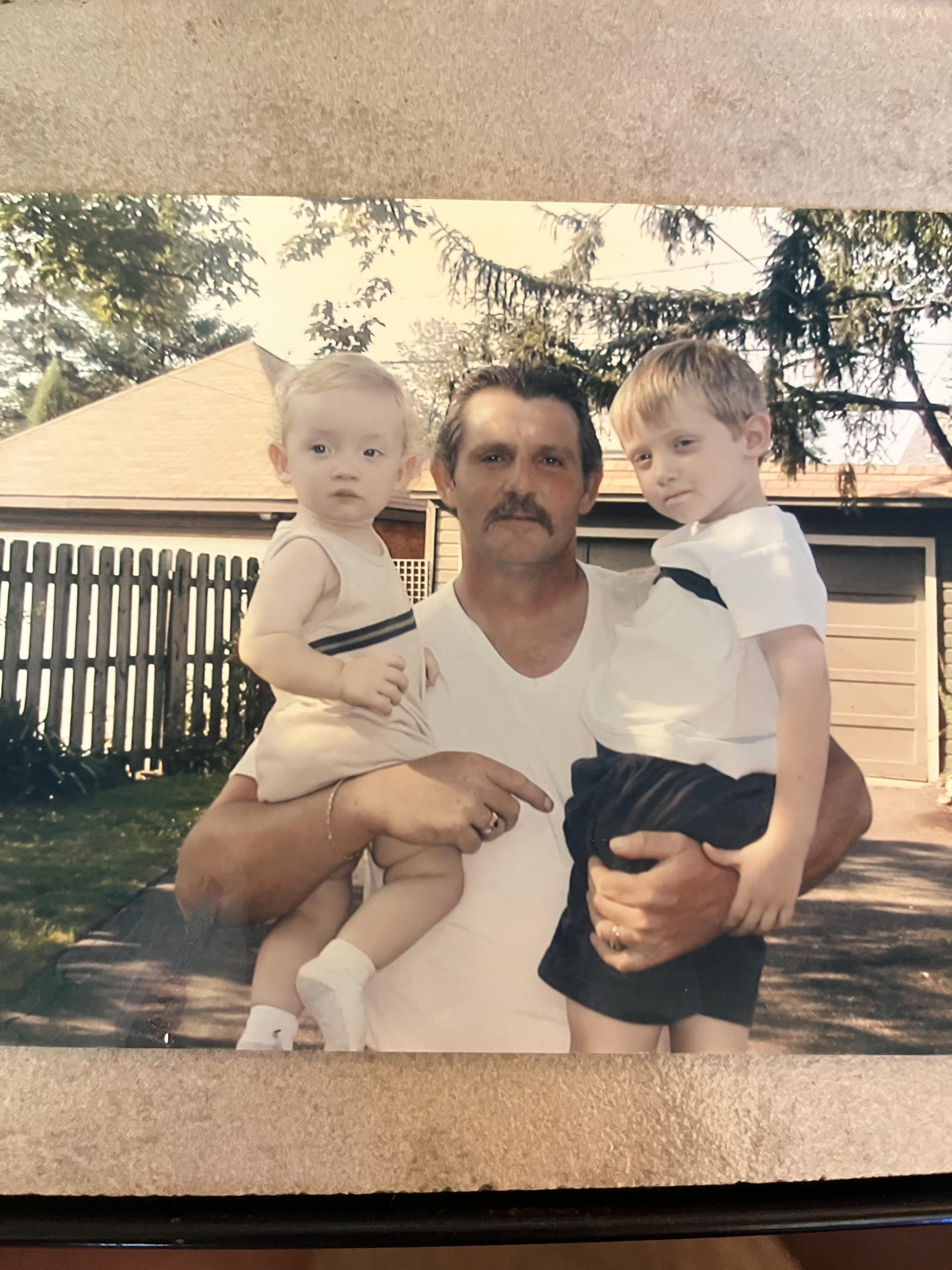A man holding two boys