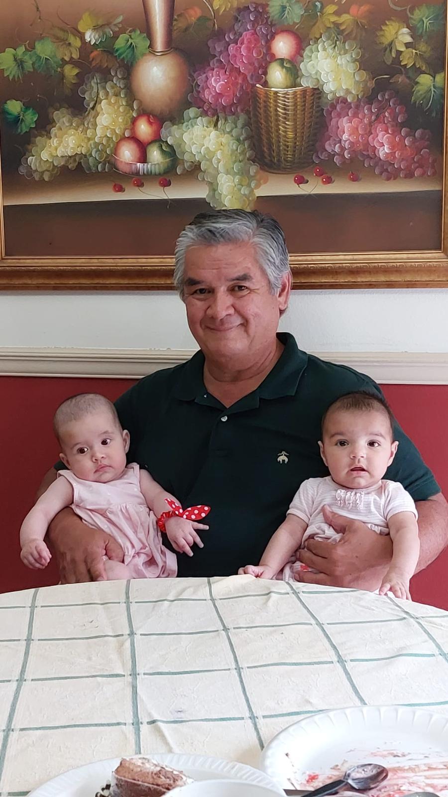 A man holding two babies
