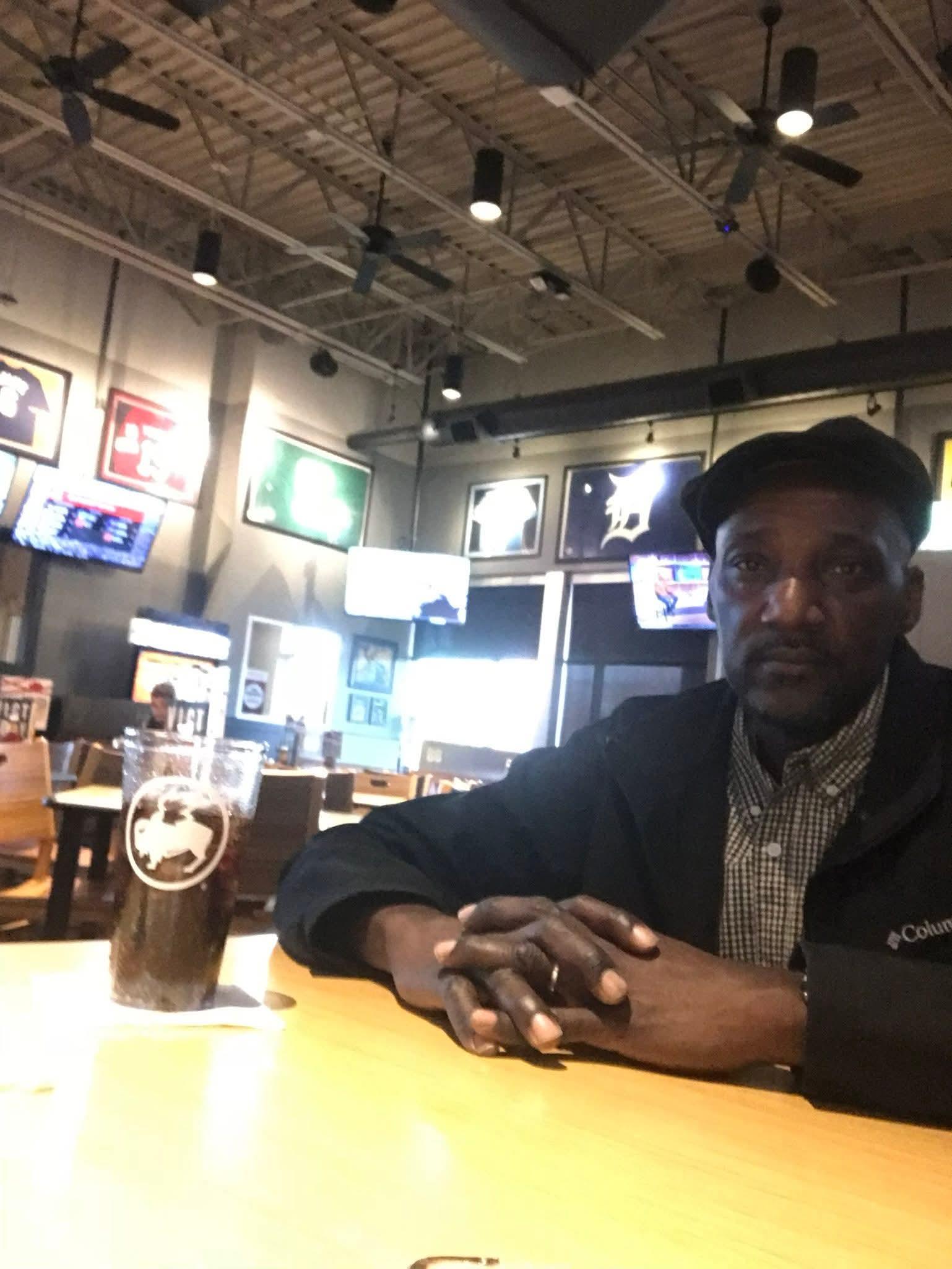 A man sitting at a table with a drink