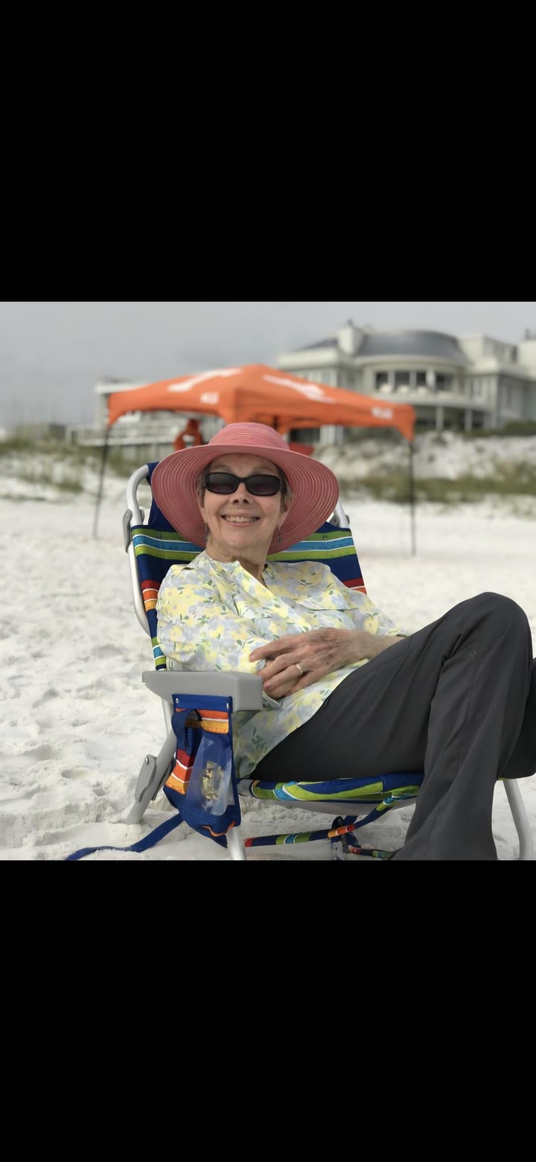 A woman sitting in a chair on the beach