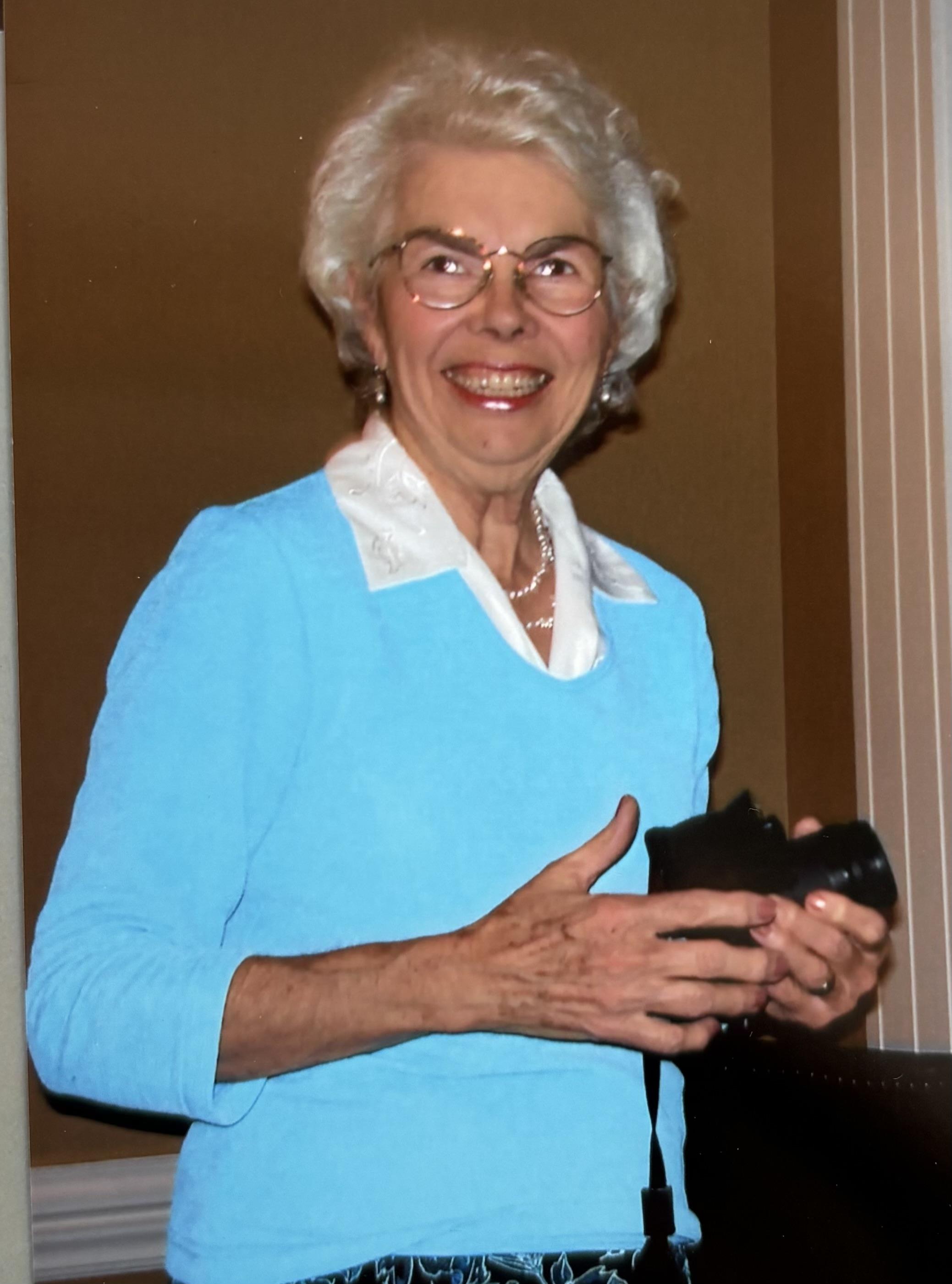 A woman smiling and holding a purse