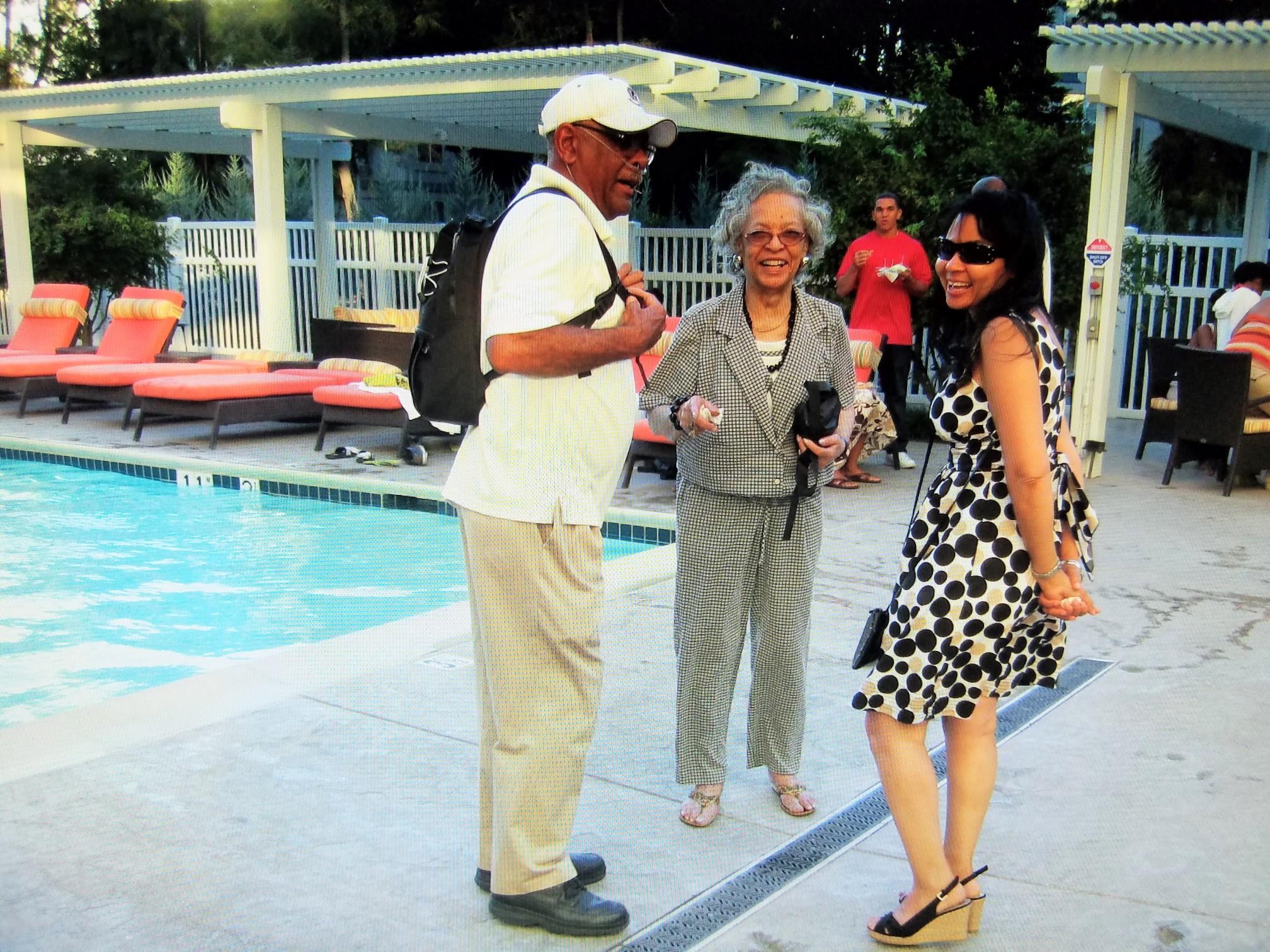 A group of people standing next to a pool