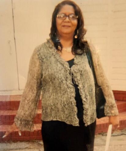 A woman standing in front of a white wall