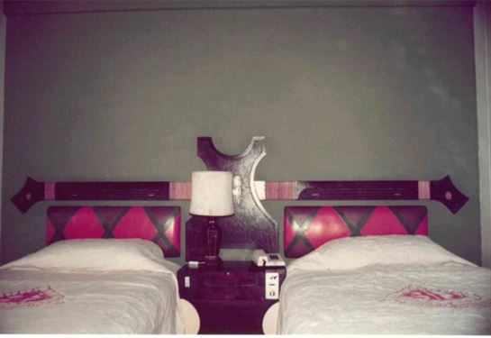 A room with two beds and a lamp