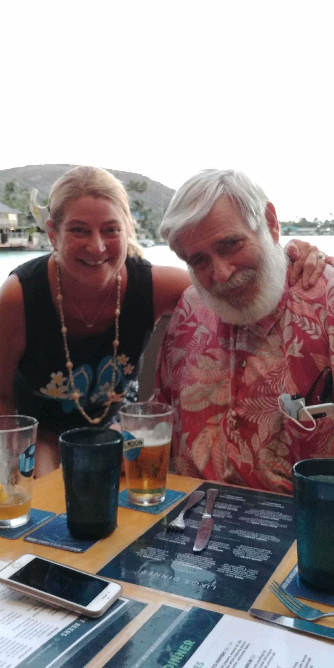 A man and woman sitting at a table with drinks