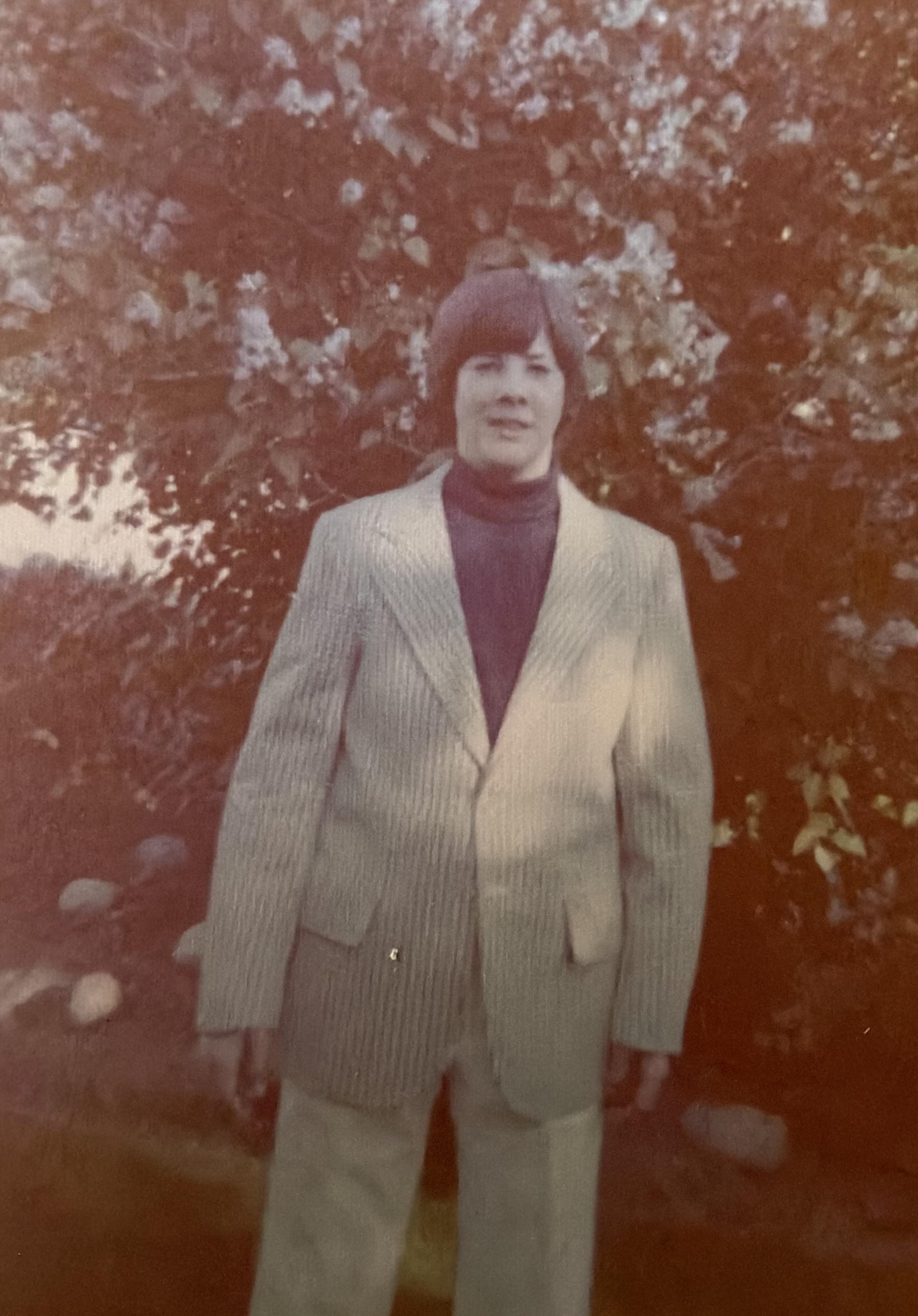 A person standing in front of a tree