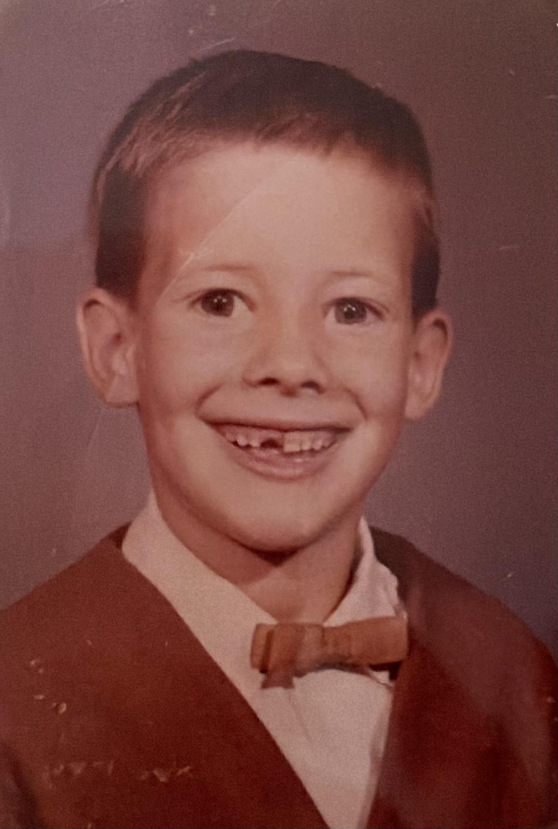 A boy smiling with missing teeth