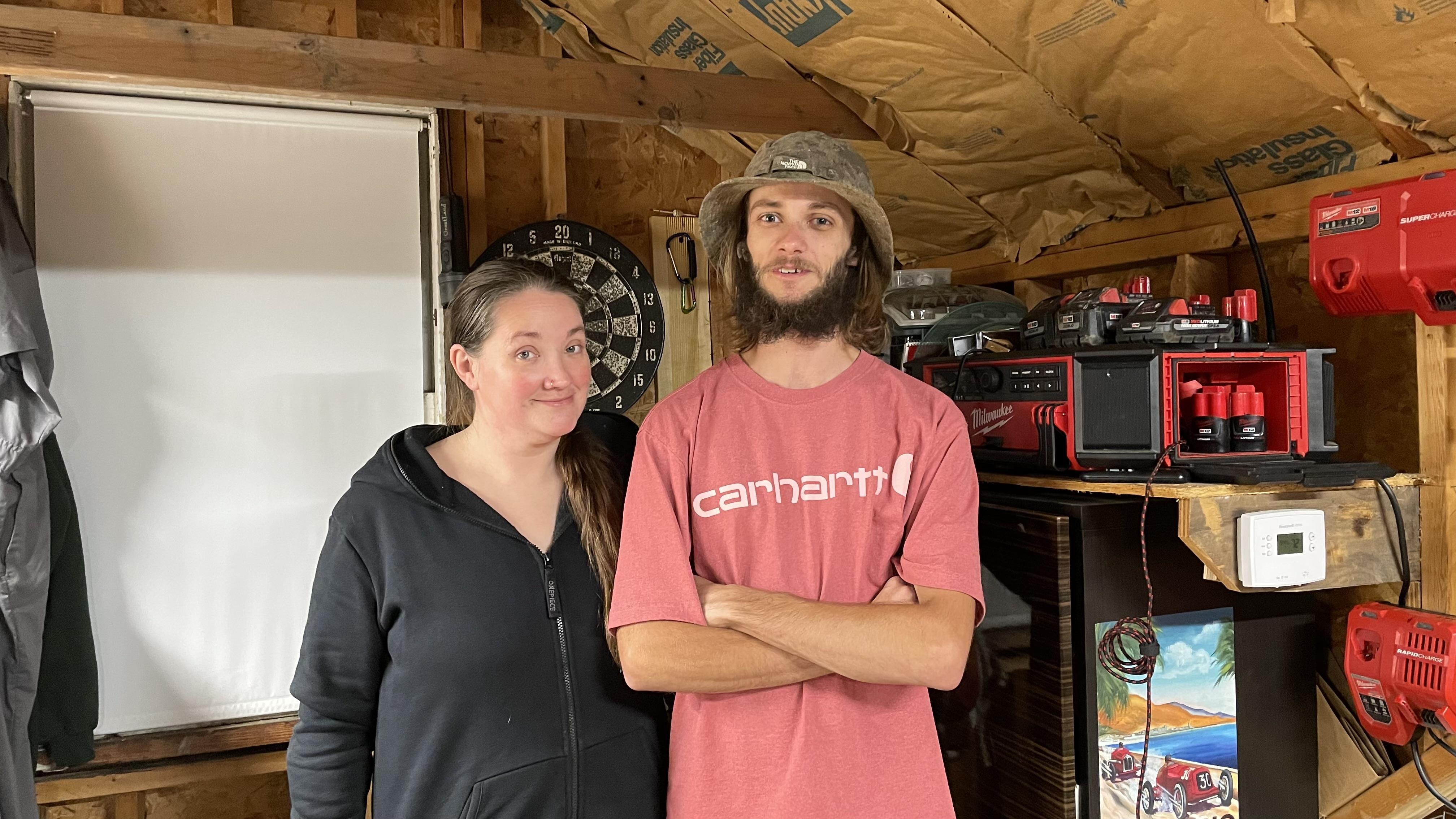 A man and woman standing in a shed