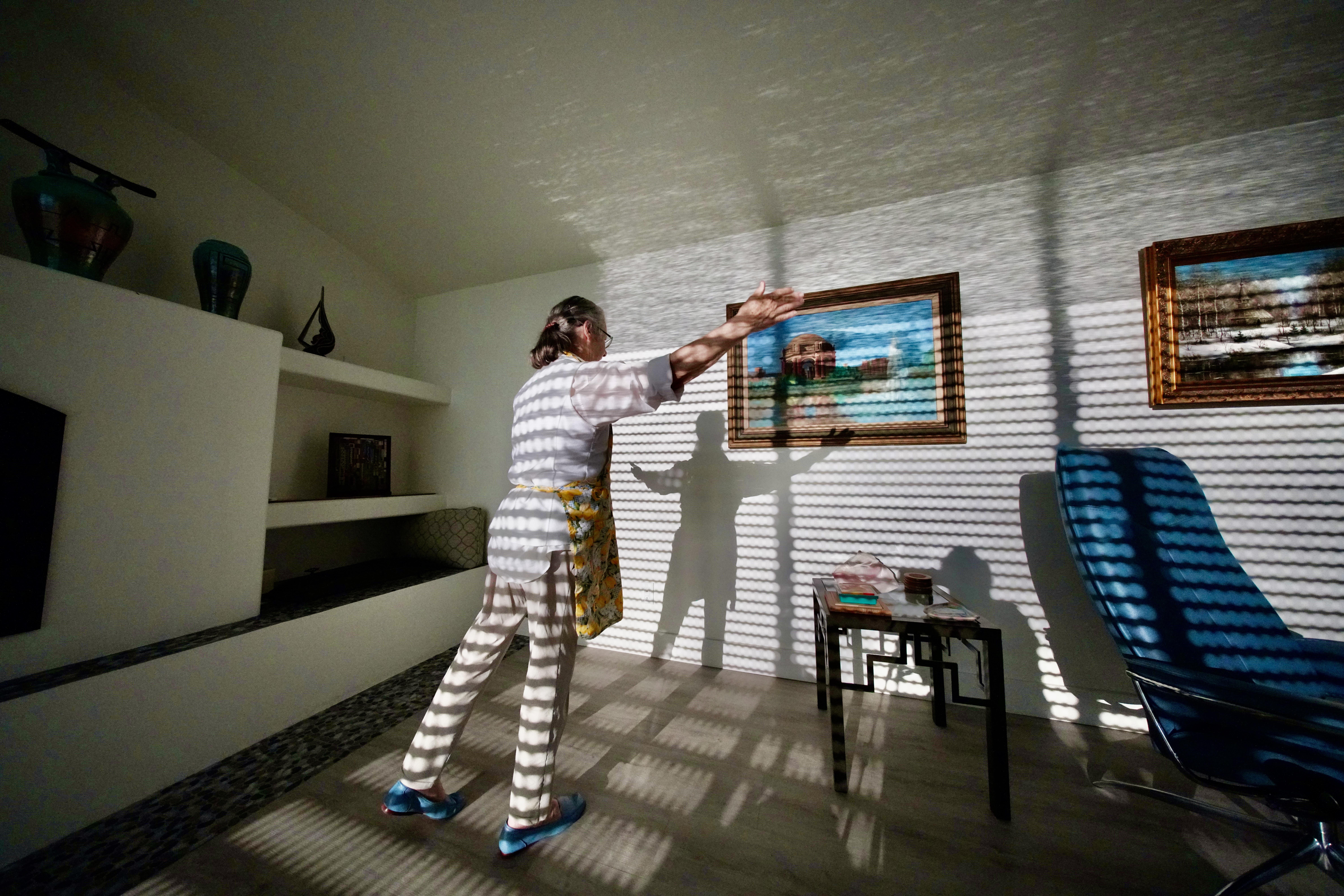 A woman reaching for a picture