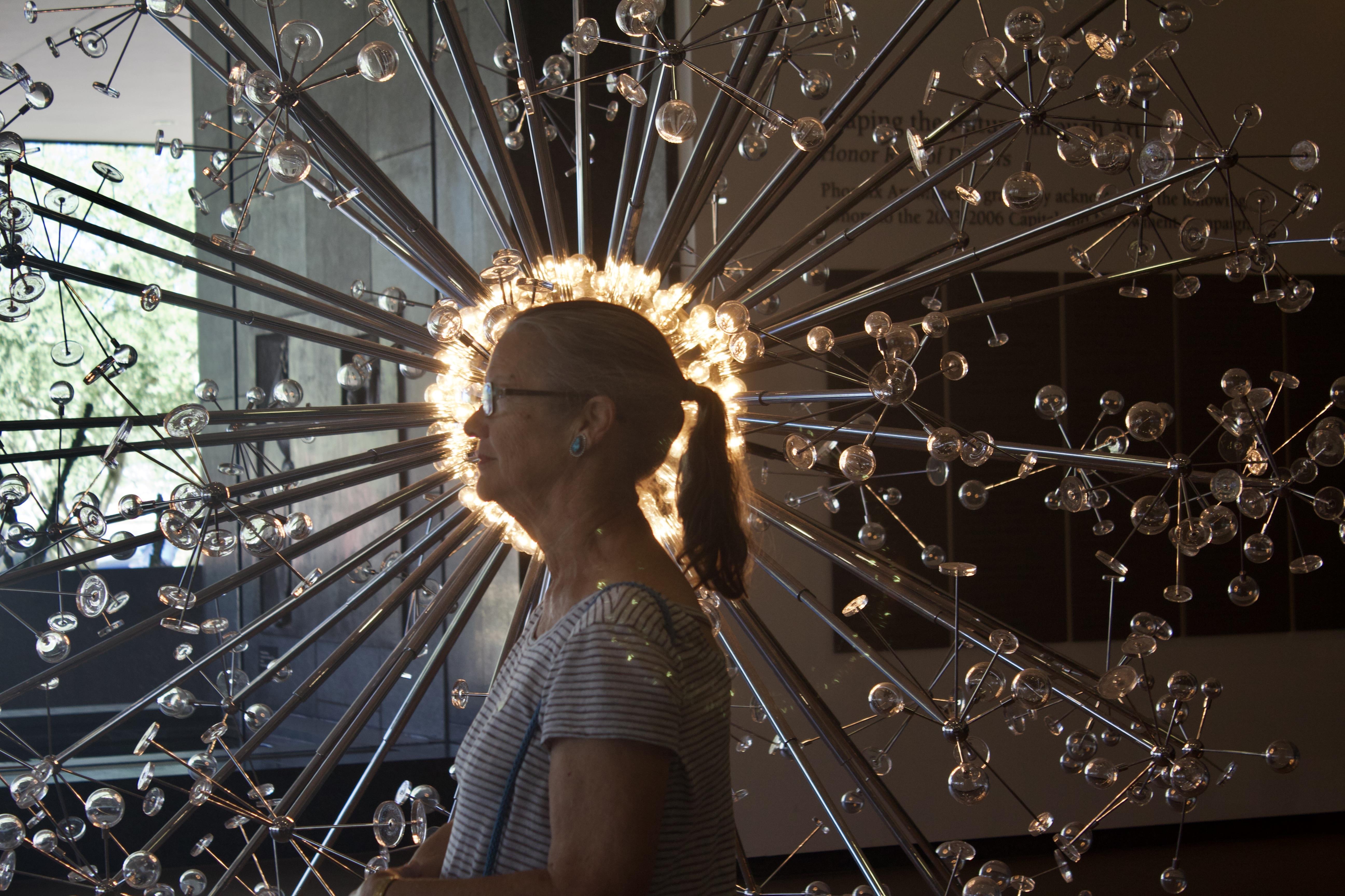 A woman standing in front of a sculpture